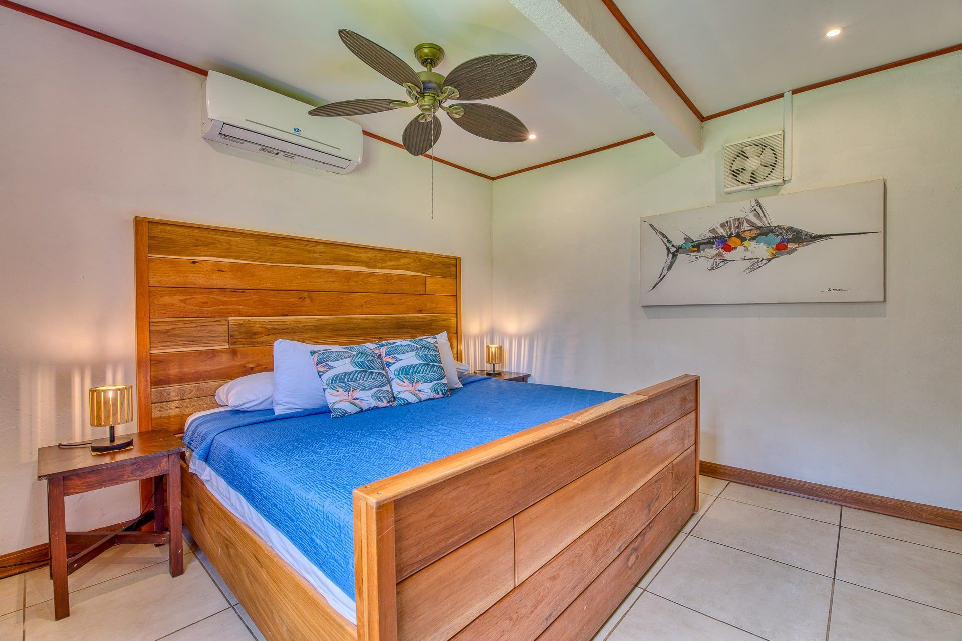 A bedroom with a king size bed and a ceiling fan.