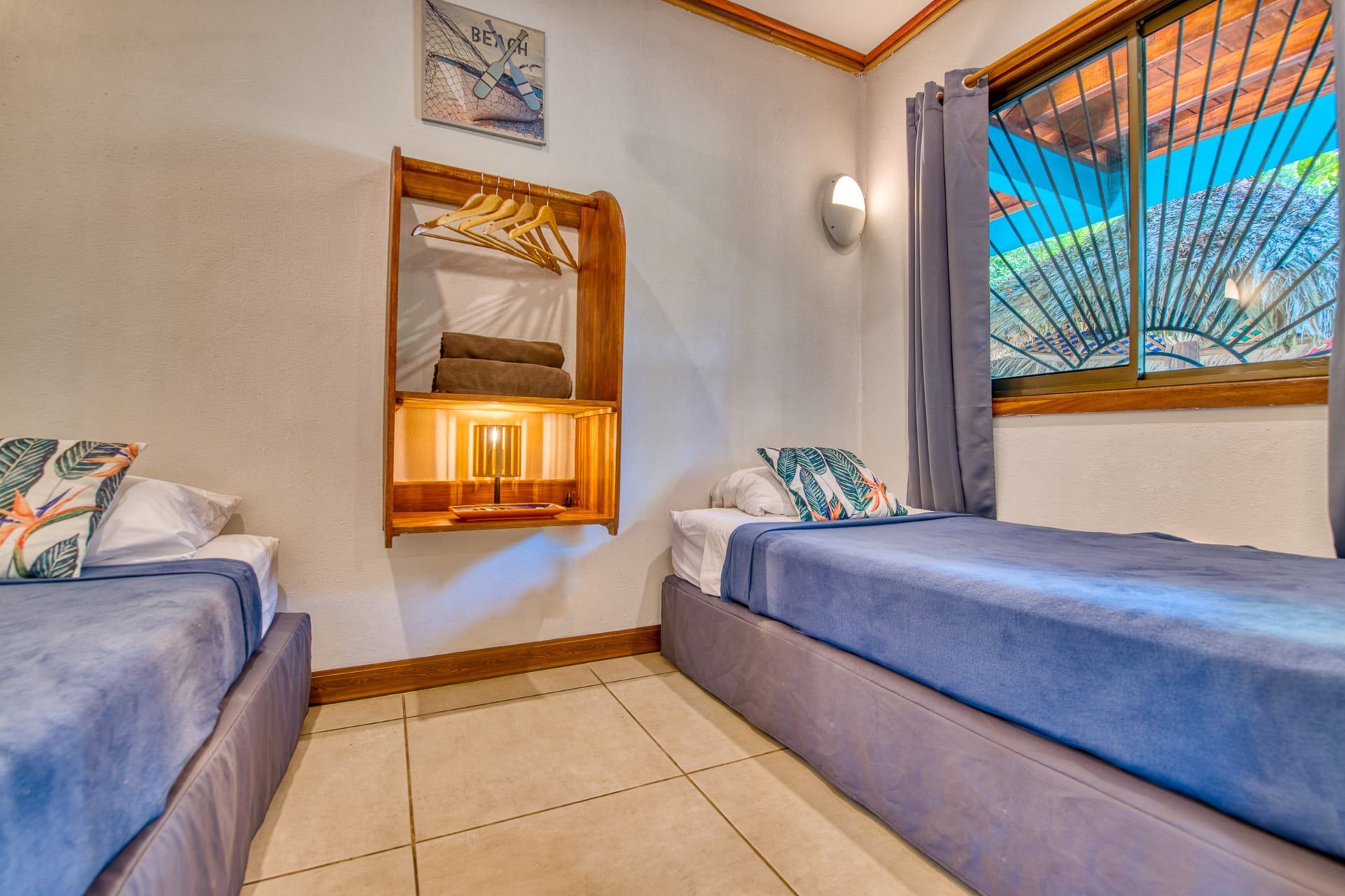 A bedroom with two twin beds and a window.