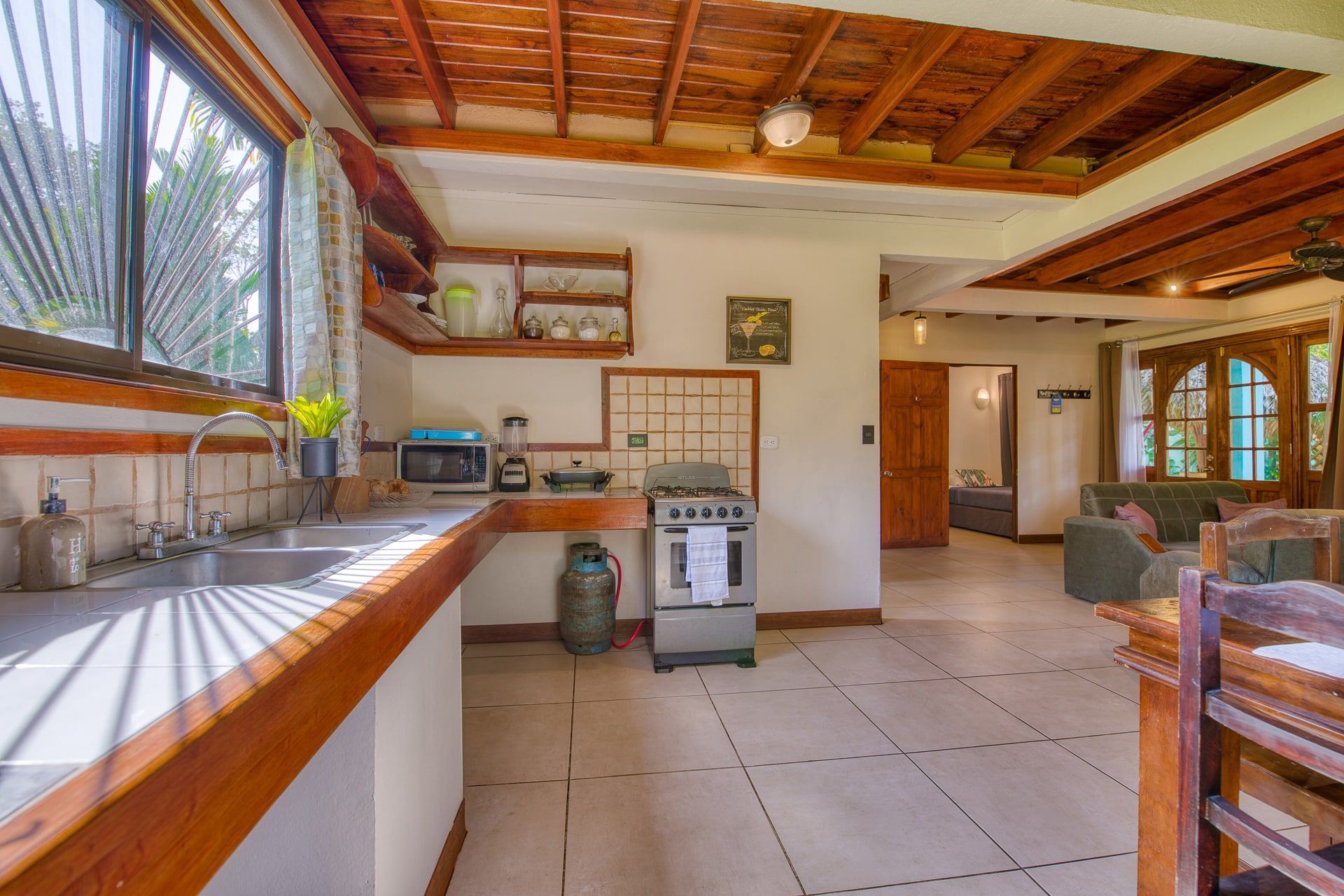 A kitchen with a sink , stove and microwave