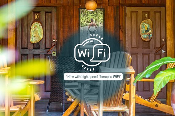A wooden porch with chairs and a sign that says wi fi.