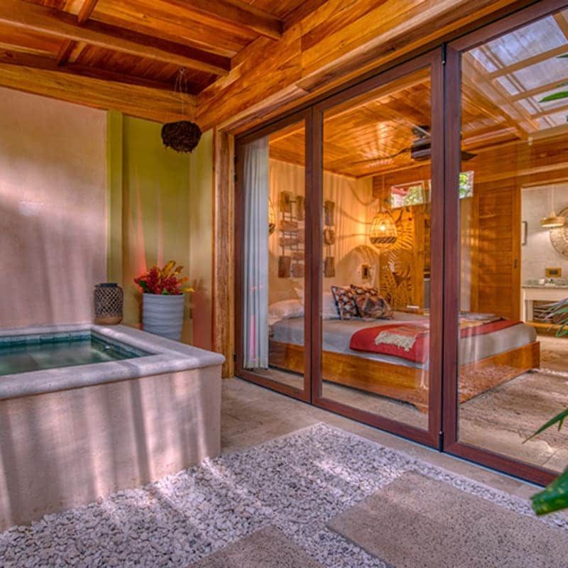A bedroom with sliding glass doors and a bathtub.