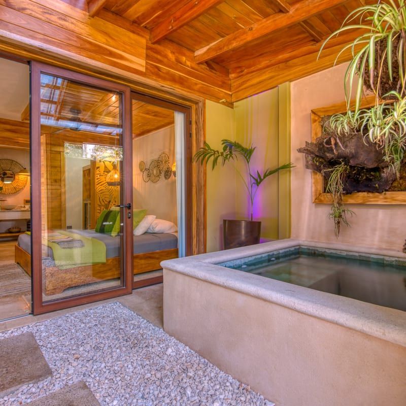 A bedroom with a sliding glass door and a bathtub