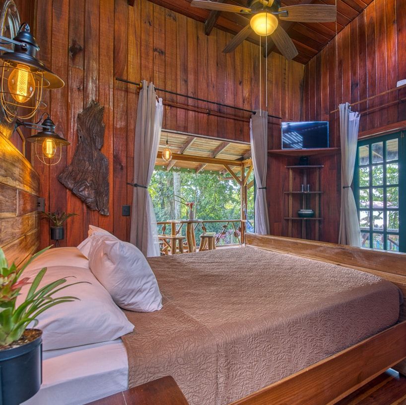 A bedroom with a large bed and a ceiling fan