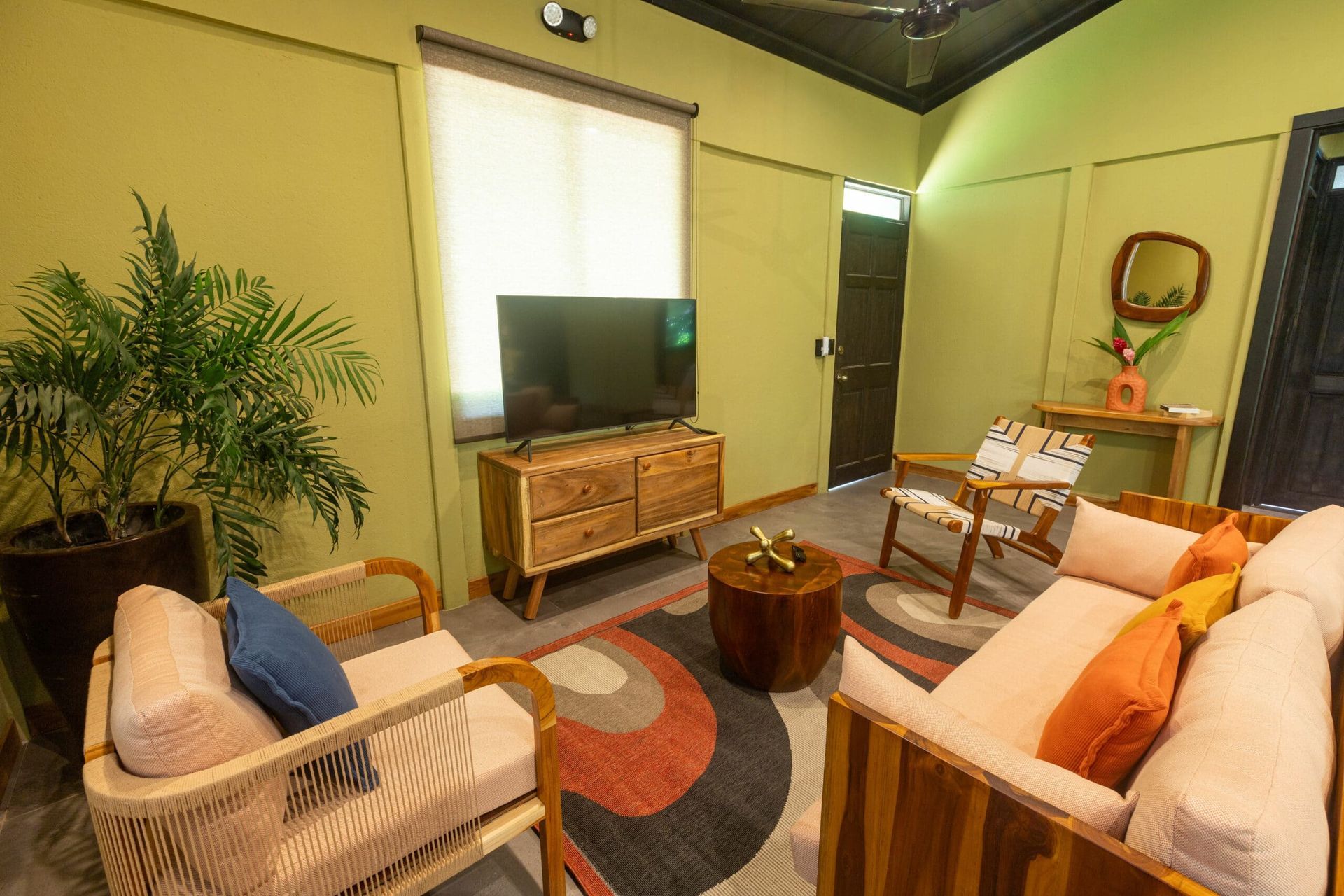 A living room with a couch , chair , table and television.