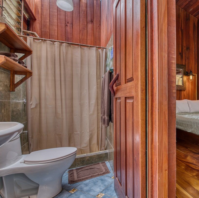A bathroom with a toilet a sink and a shower curtain