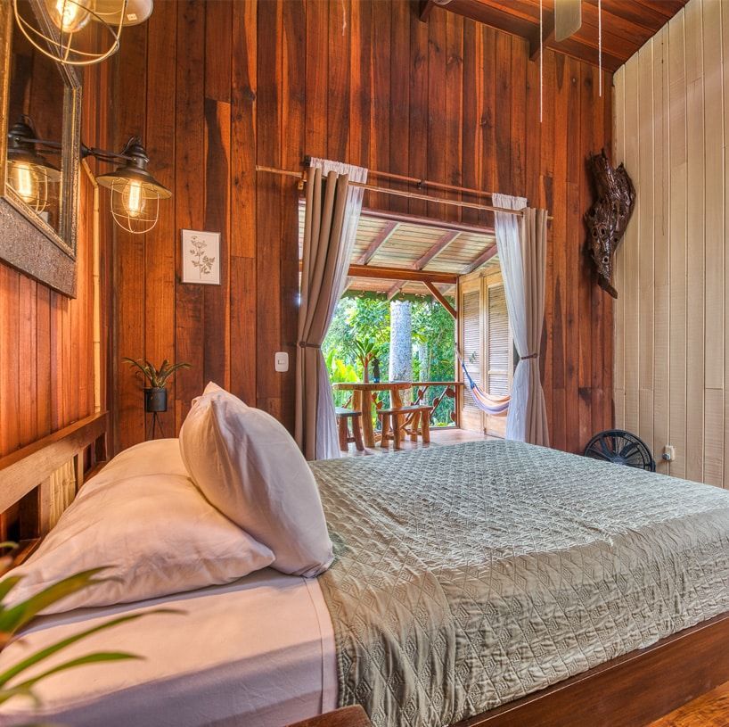 A bedroom with a king size bed and wooden walls