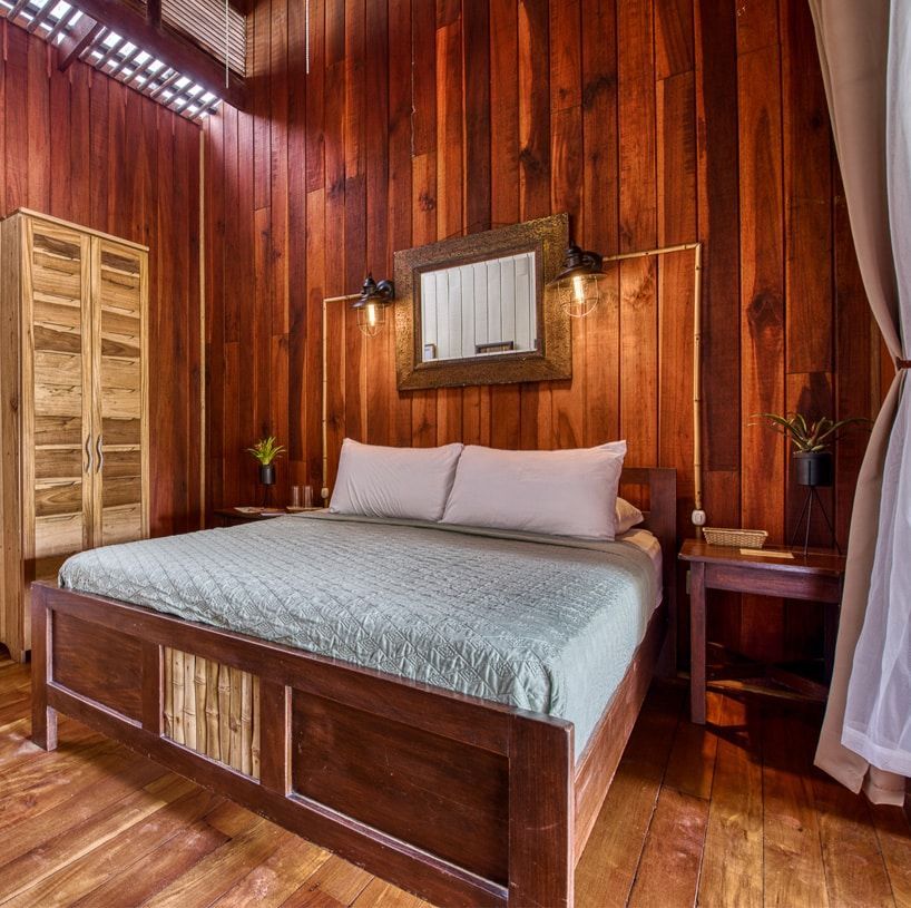 A bedroom with a bed and a mirror on the wall