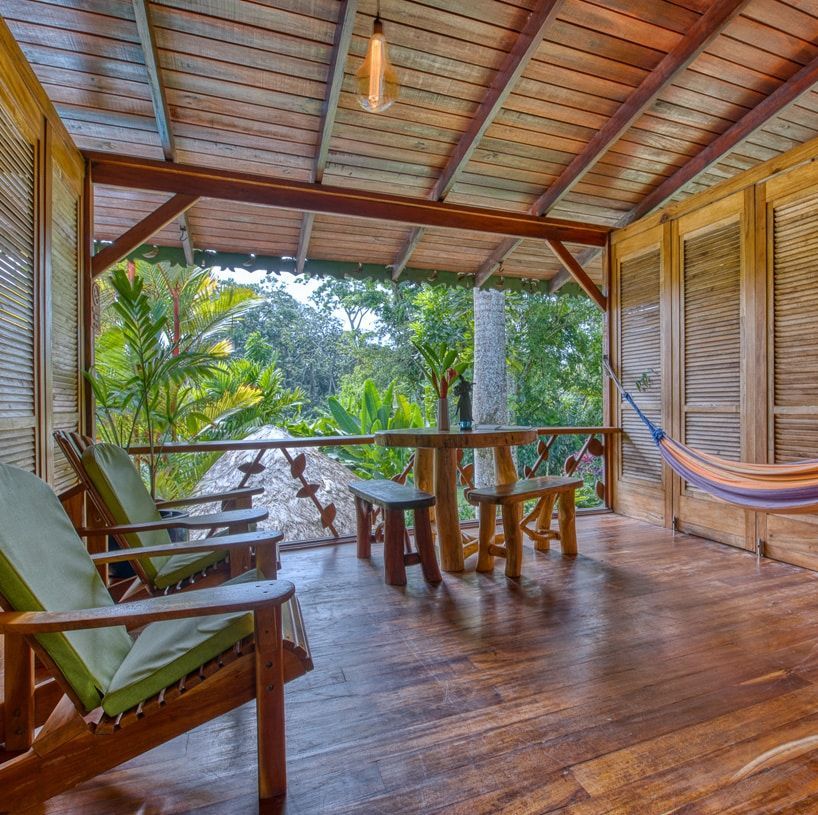 A wooden porch with chairs and a hammock