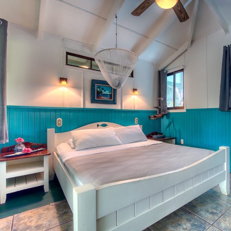 A bedroom with a bed and a ceiling fan