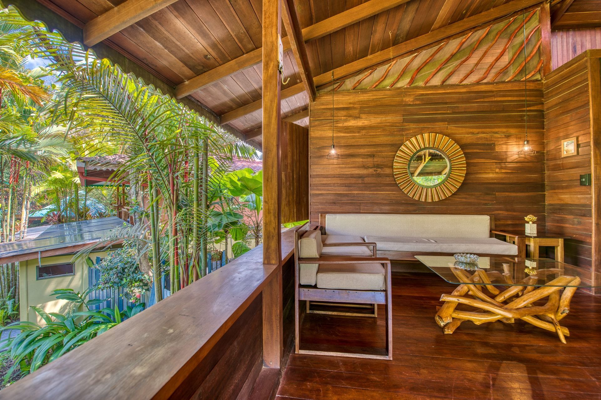 A living room with a couch , chairs , a table and a clock on the wall.