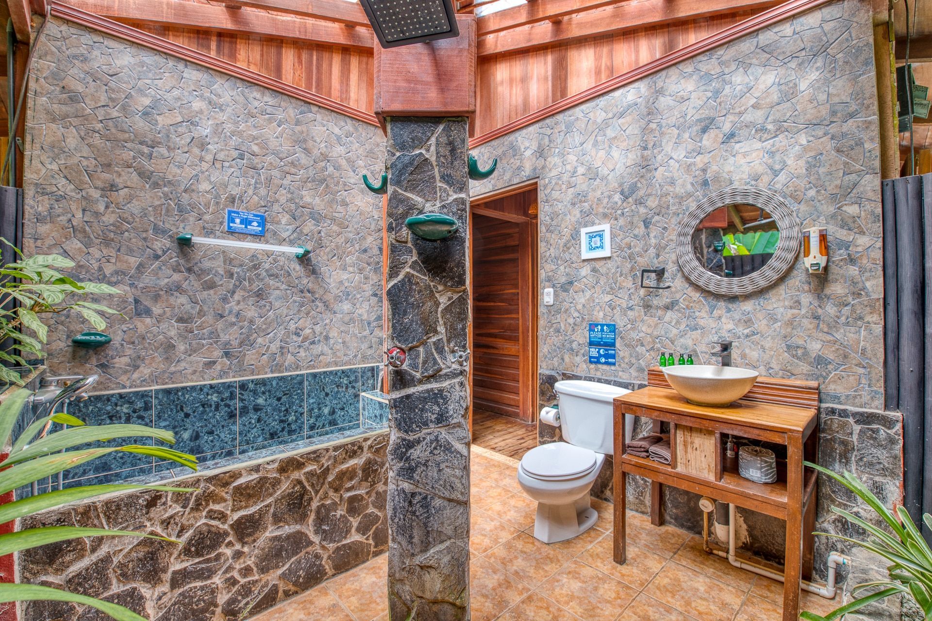 A bathroom with a toilet , sink and shower.