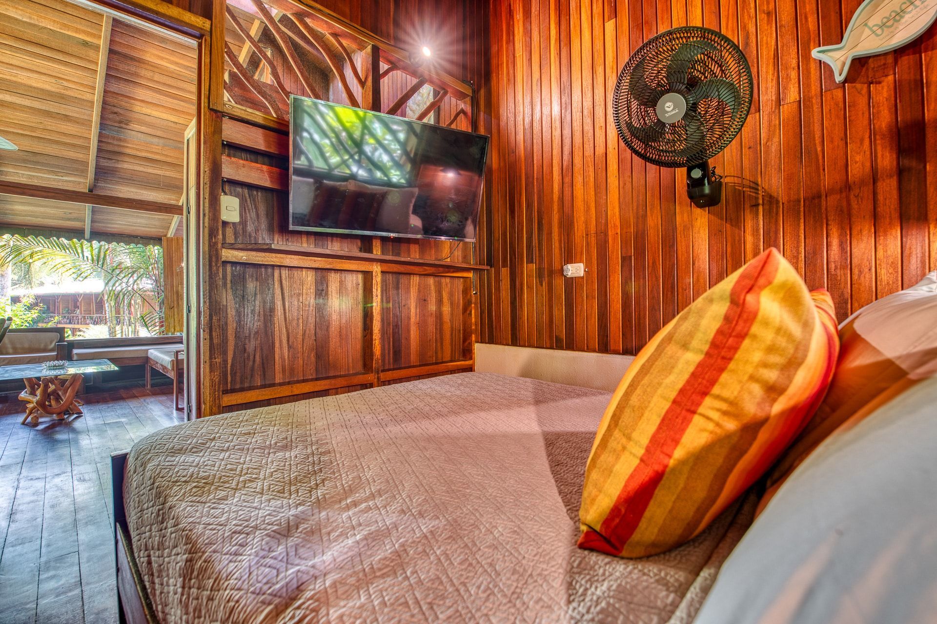 A bedroom with a bed and a fan on the wall