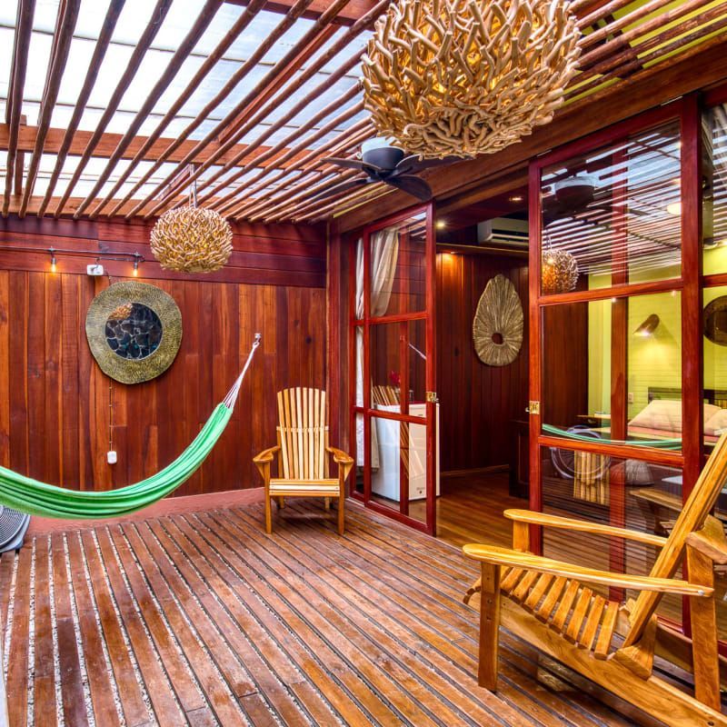 A wooden deck with a hammock and chairs on it