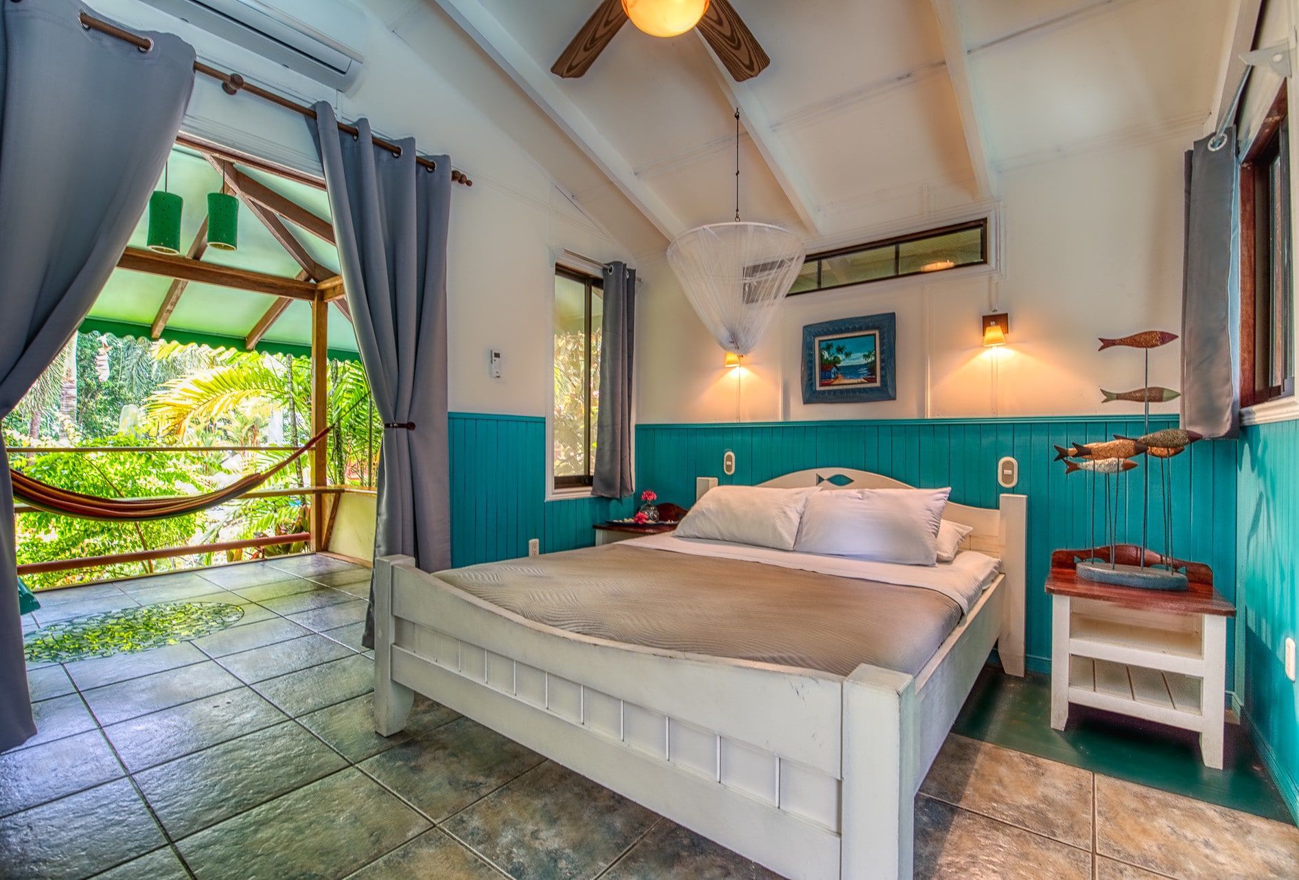 A bedroom with a king size bed and a ceiling fan.