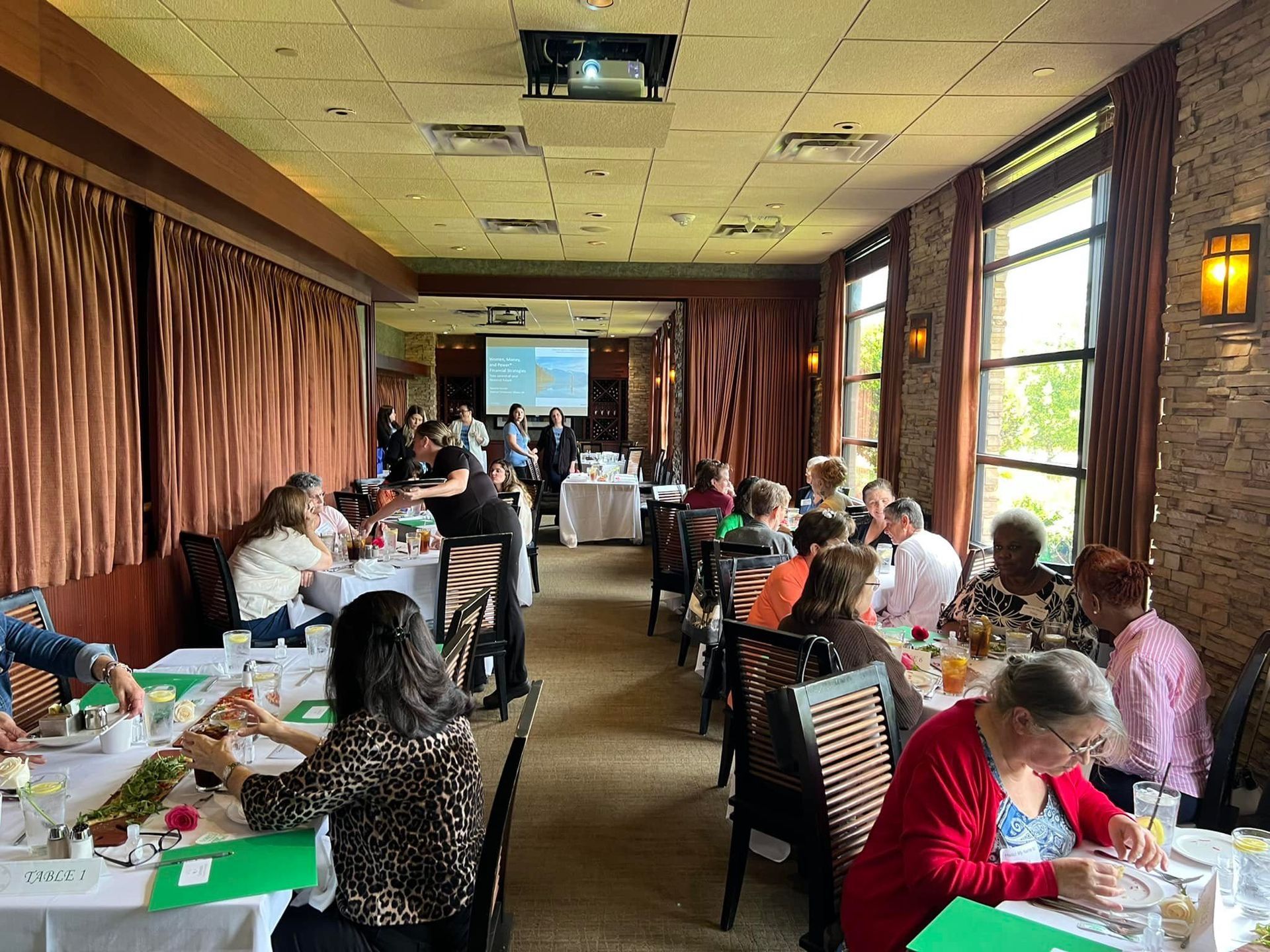 A group of people are sitting at tables in a restaurant.