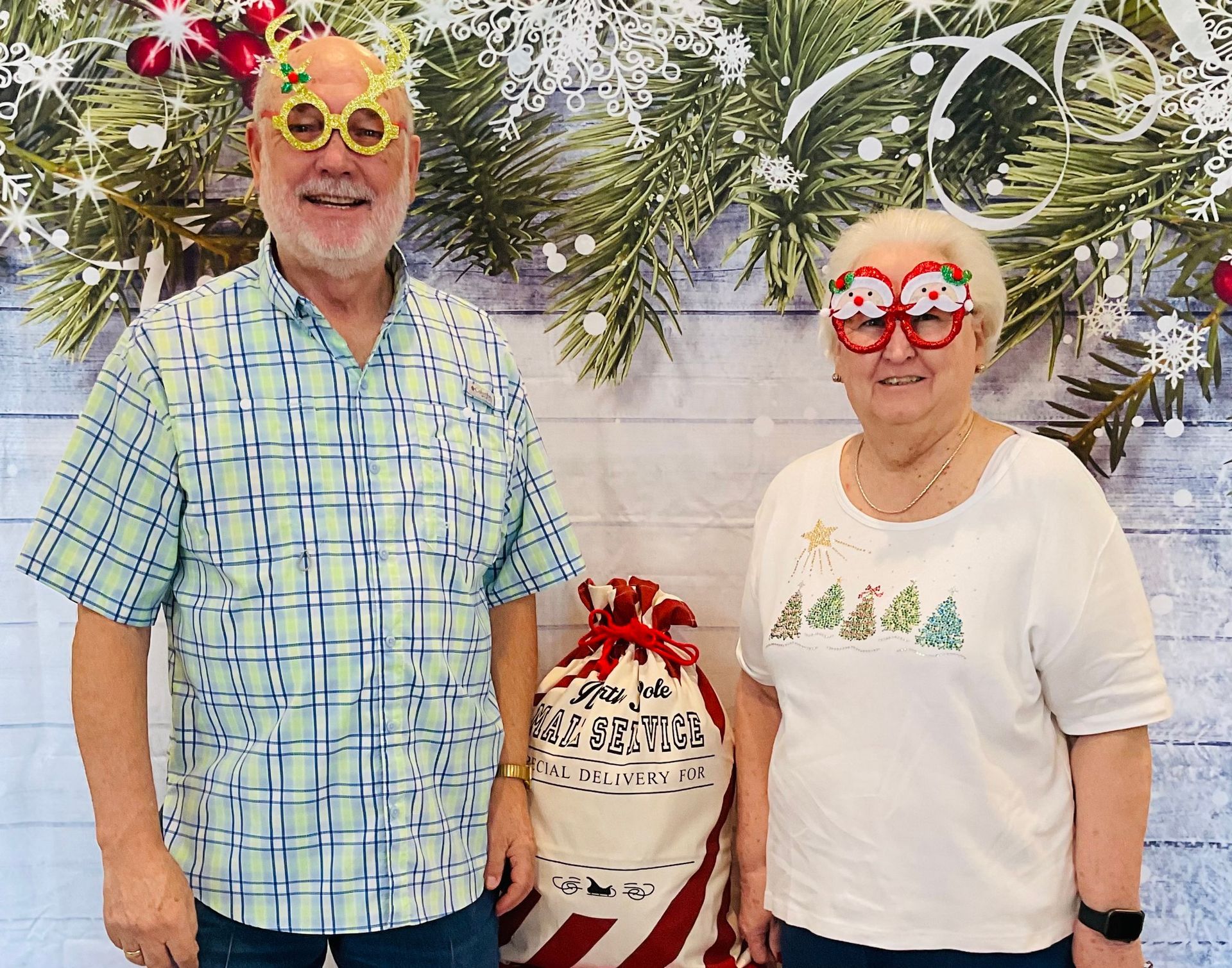 A man and a woman wearing christmas glasses are posing for a picture.