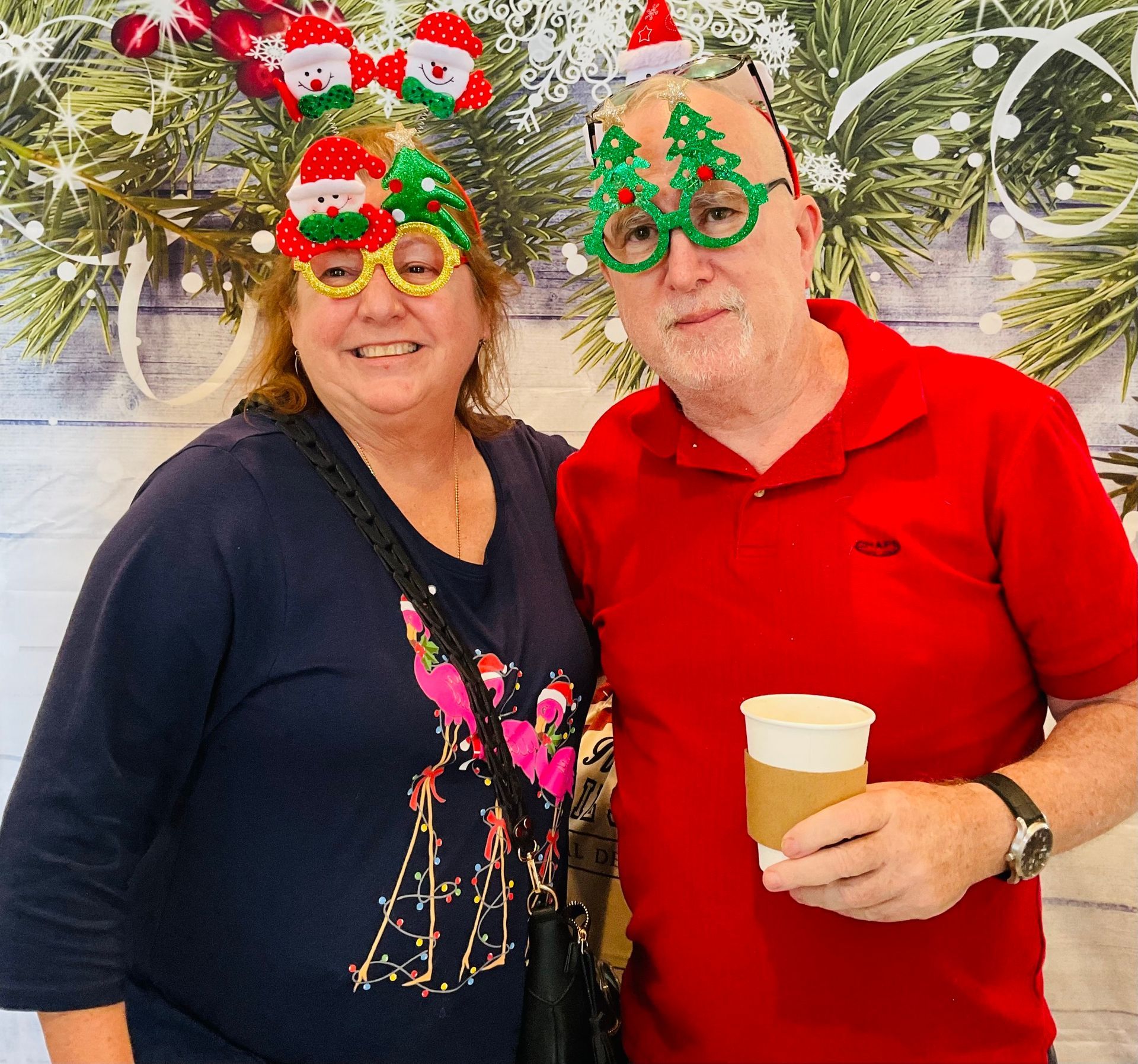 A man and a woman wearing christmas glasses are posing for a picture.