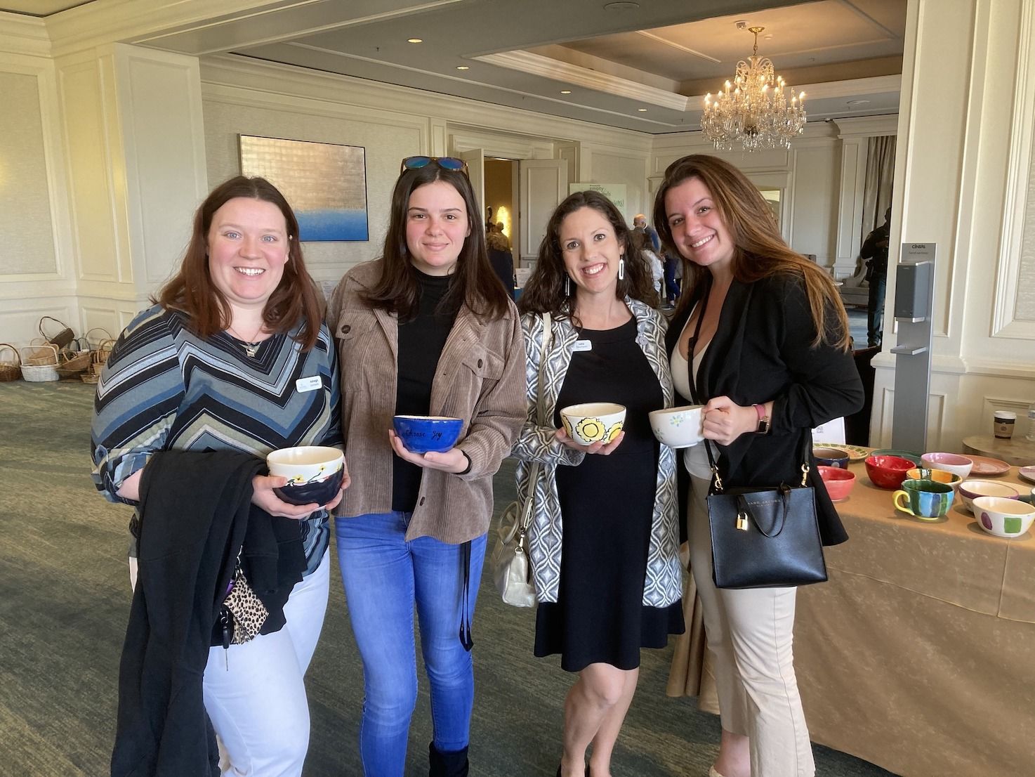 A group of women are posing for a picture while holding bowls.