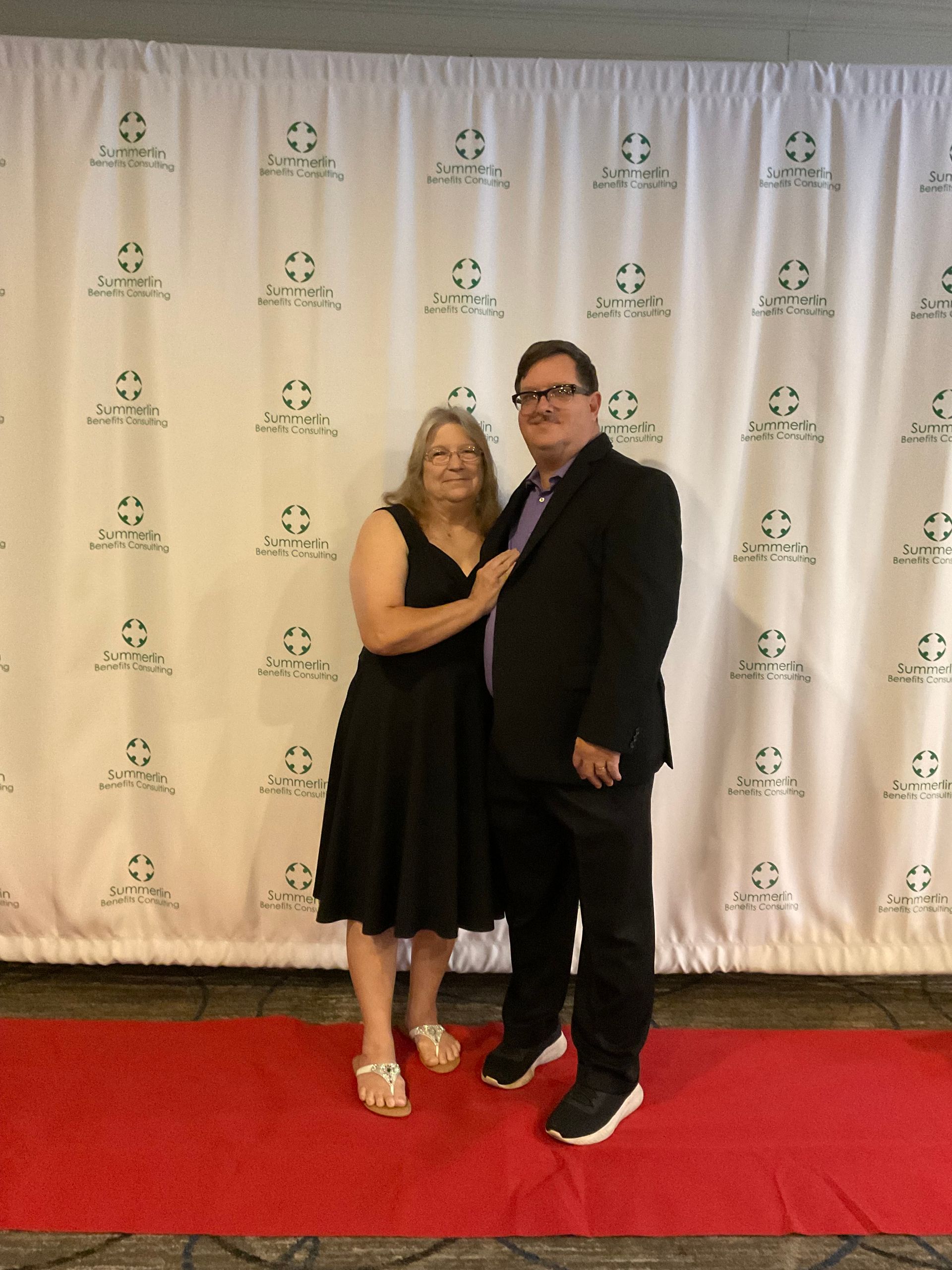 A man and woman are posing for a picture on a red carpet