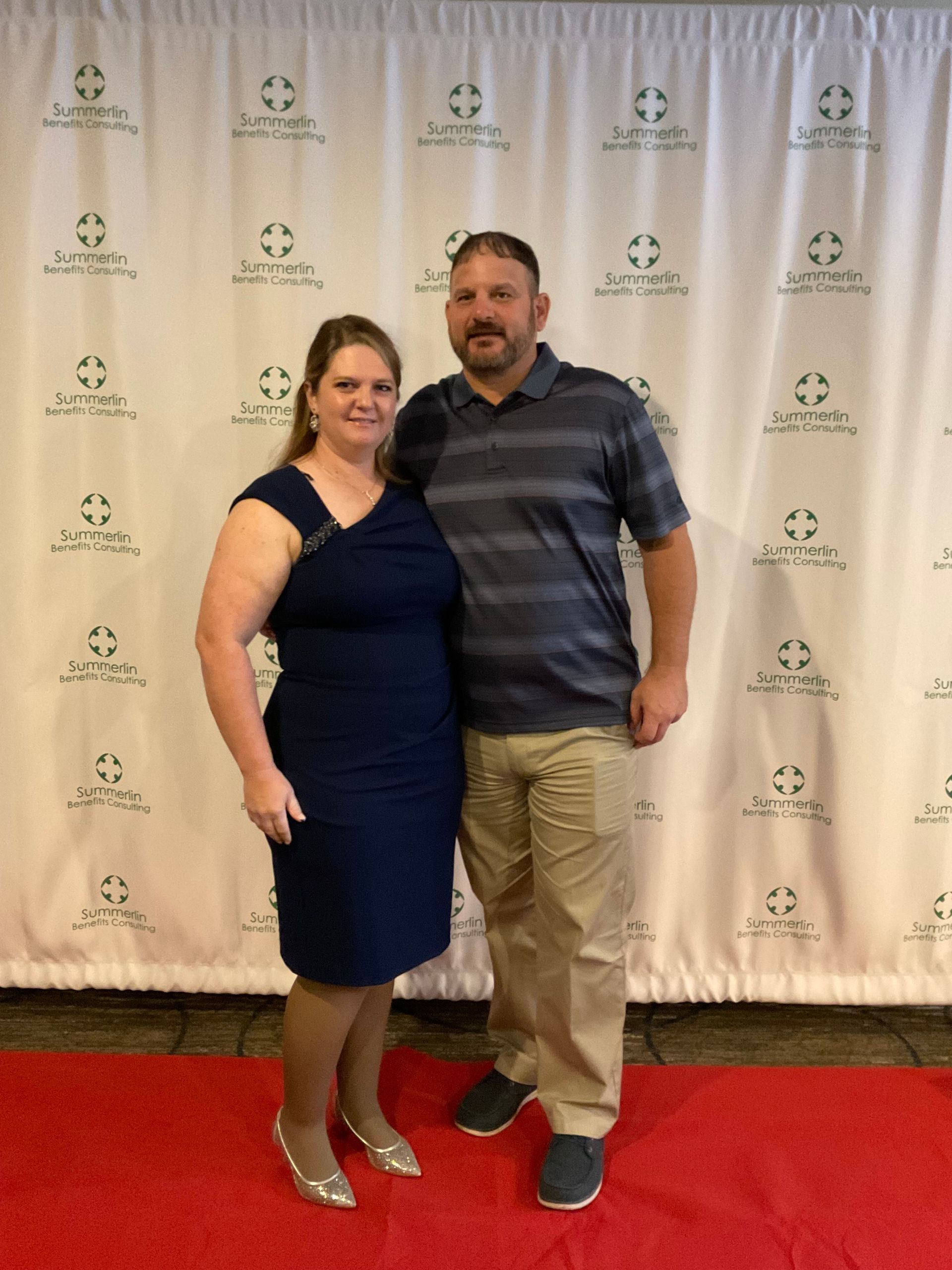 A man and a woman are posing for a picture on a red carpet