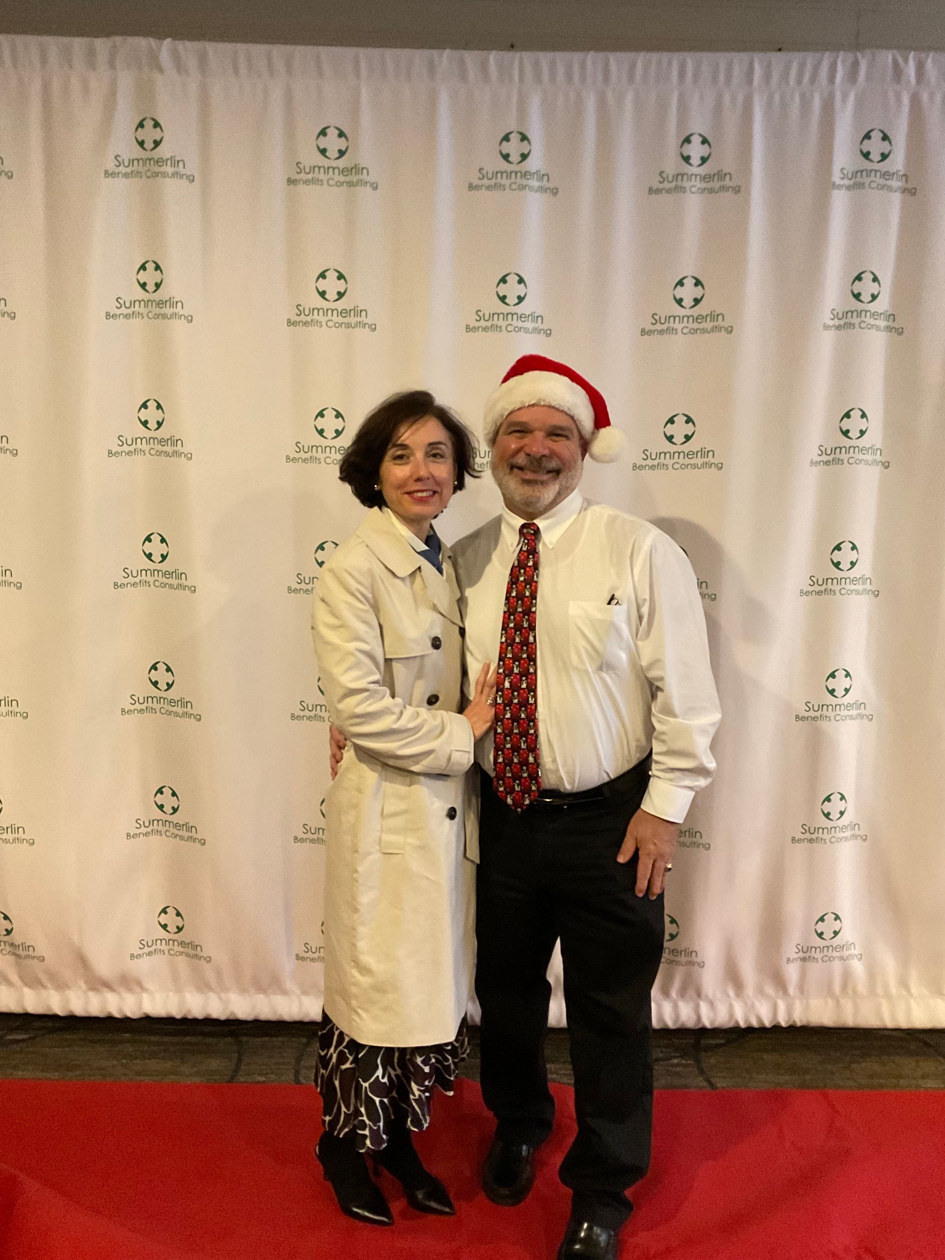A man and woman are posing for a picture on a red carpet
