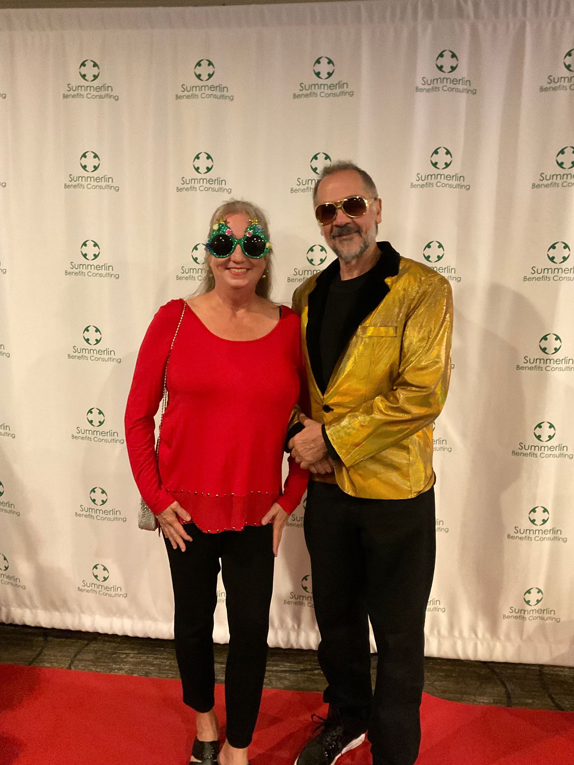 A man and a woman are posing for a picture on a red carpet