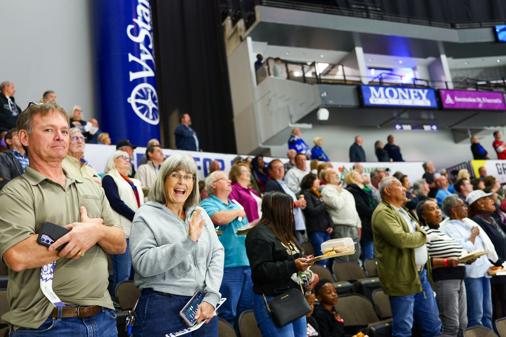 A large group of people are sitting in a stadium watching a game.