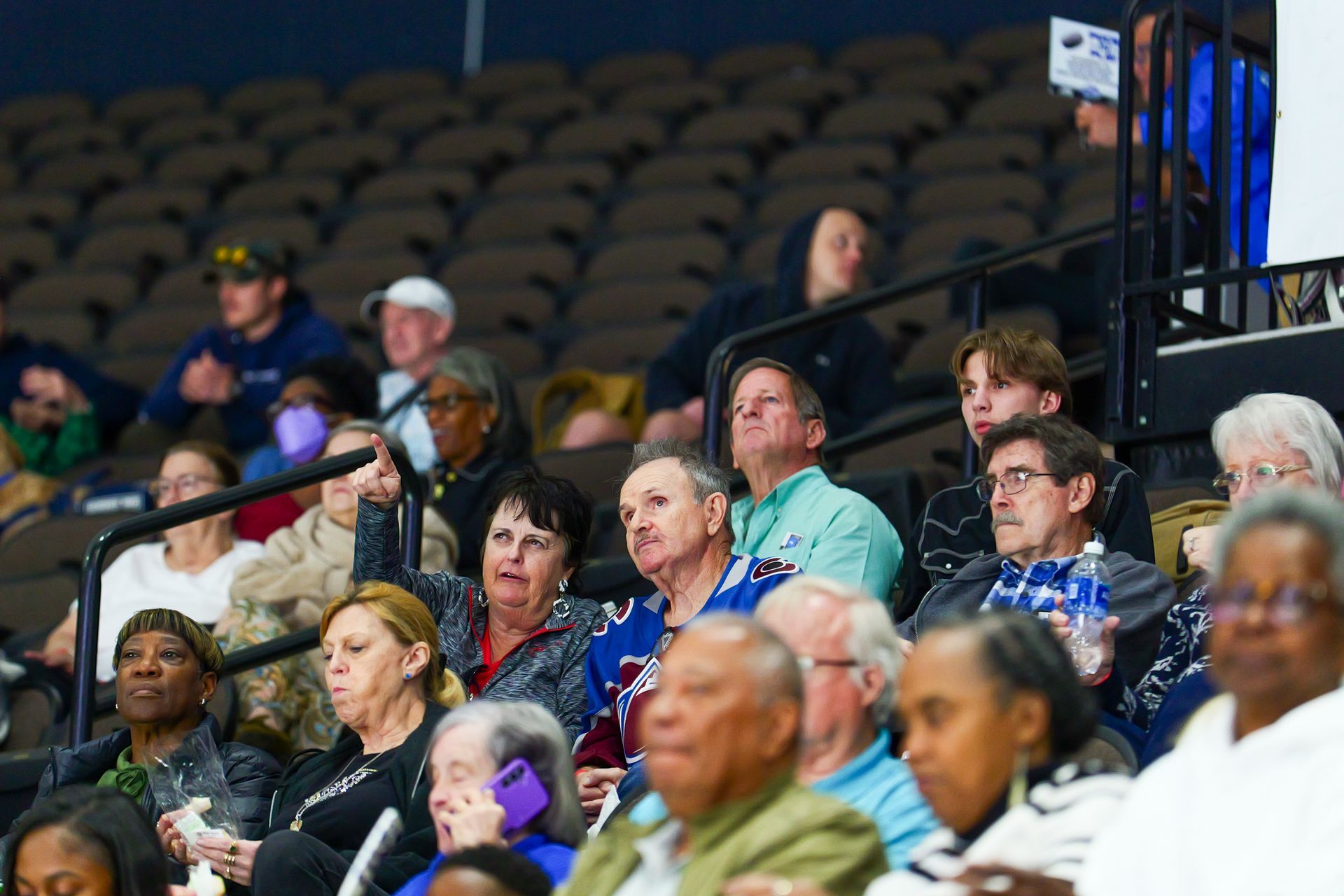 A large group of people are sitting in a stadium watching a game.
