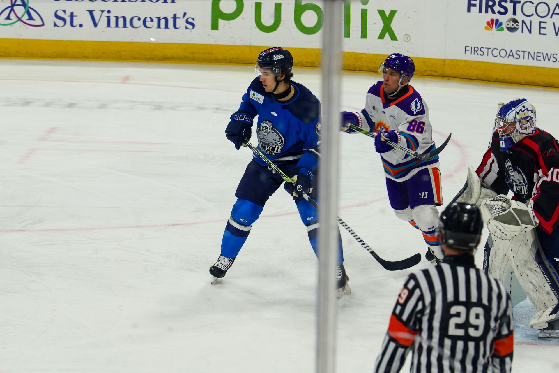 A hockey game is being played in front of an advertisement for publix