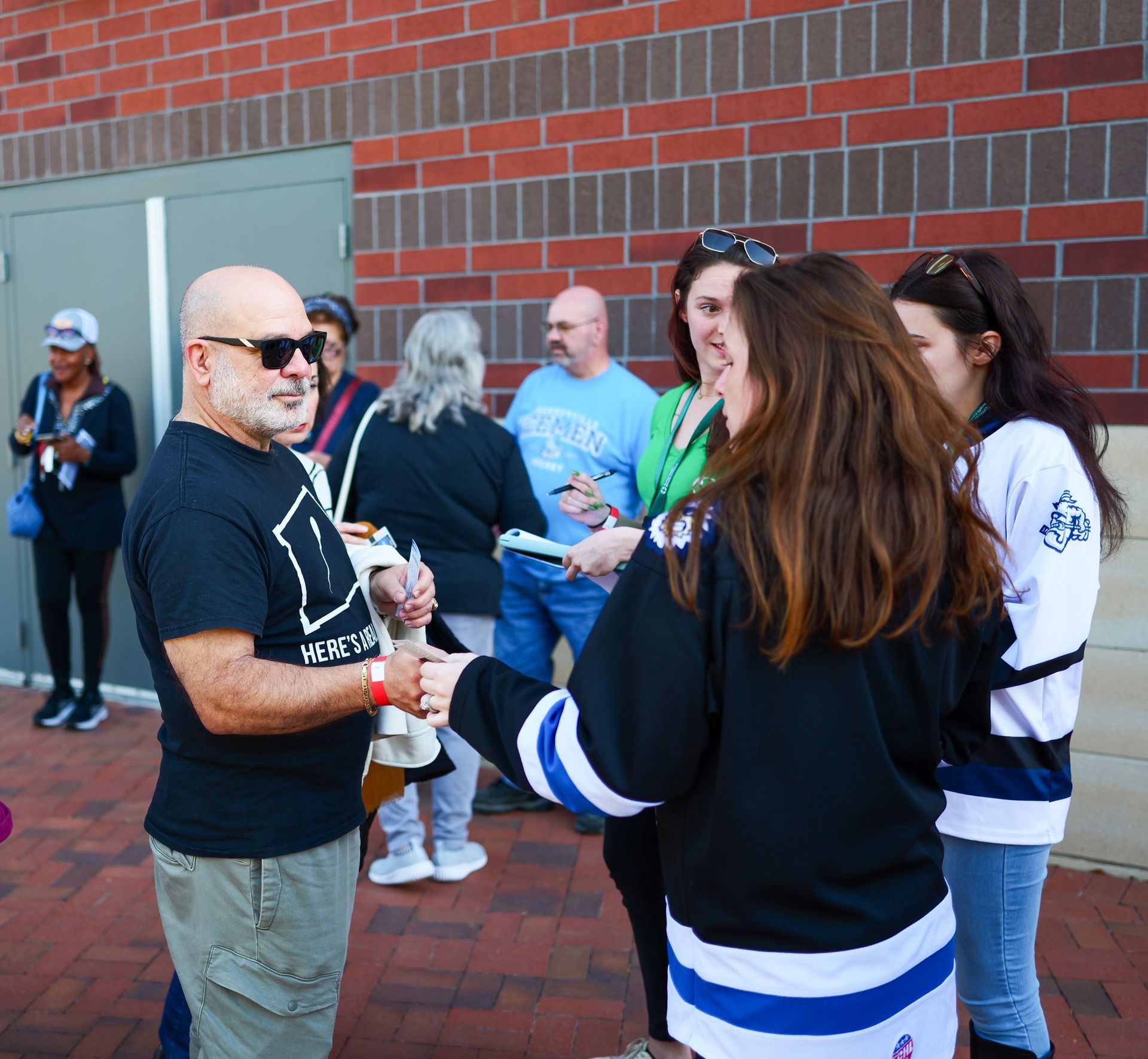 A group of people are standing in front of a brick building