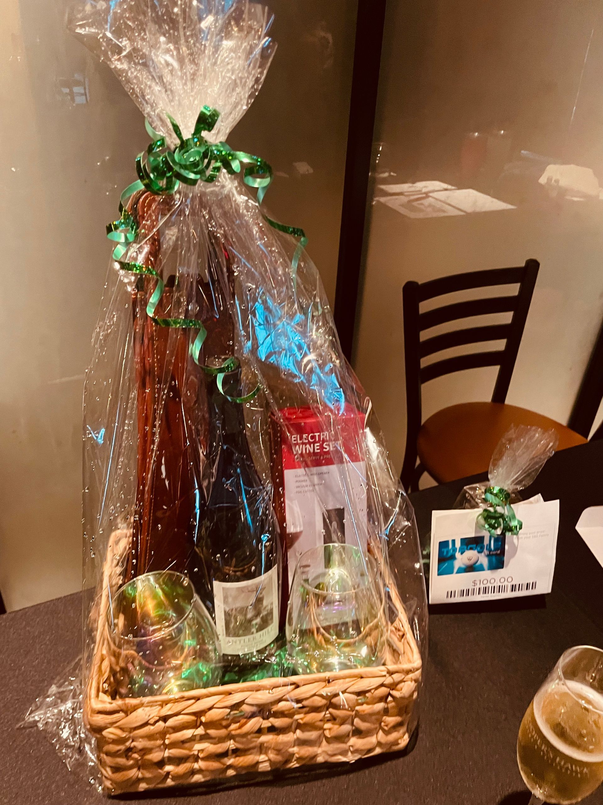 A wicker basket filled with wine bottles and glasses