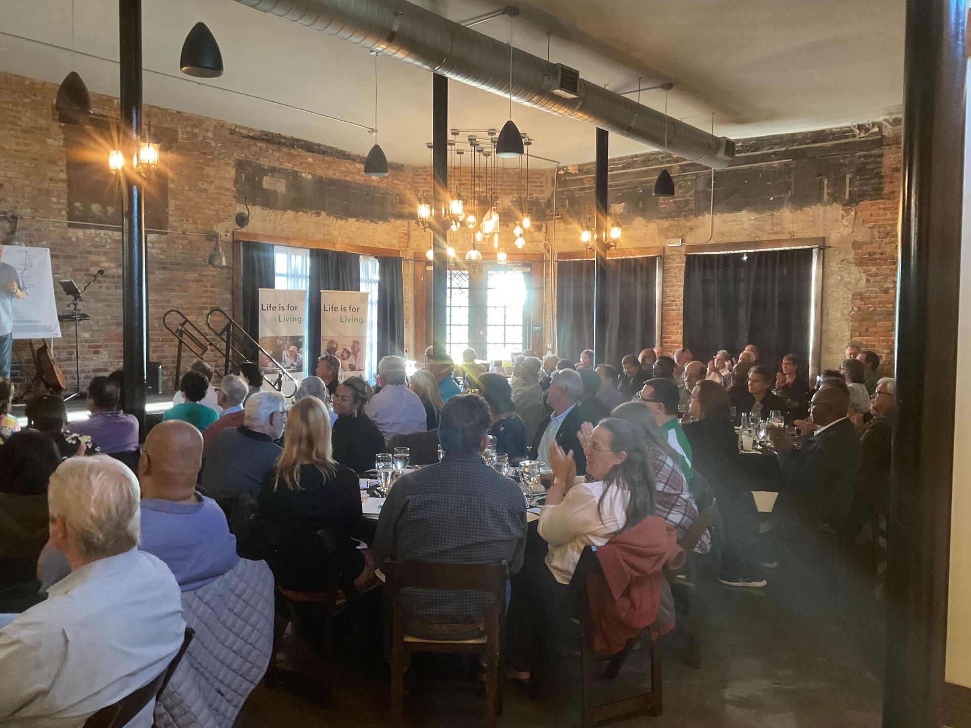 A large group of people are sitting at tables in a large room