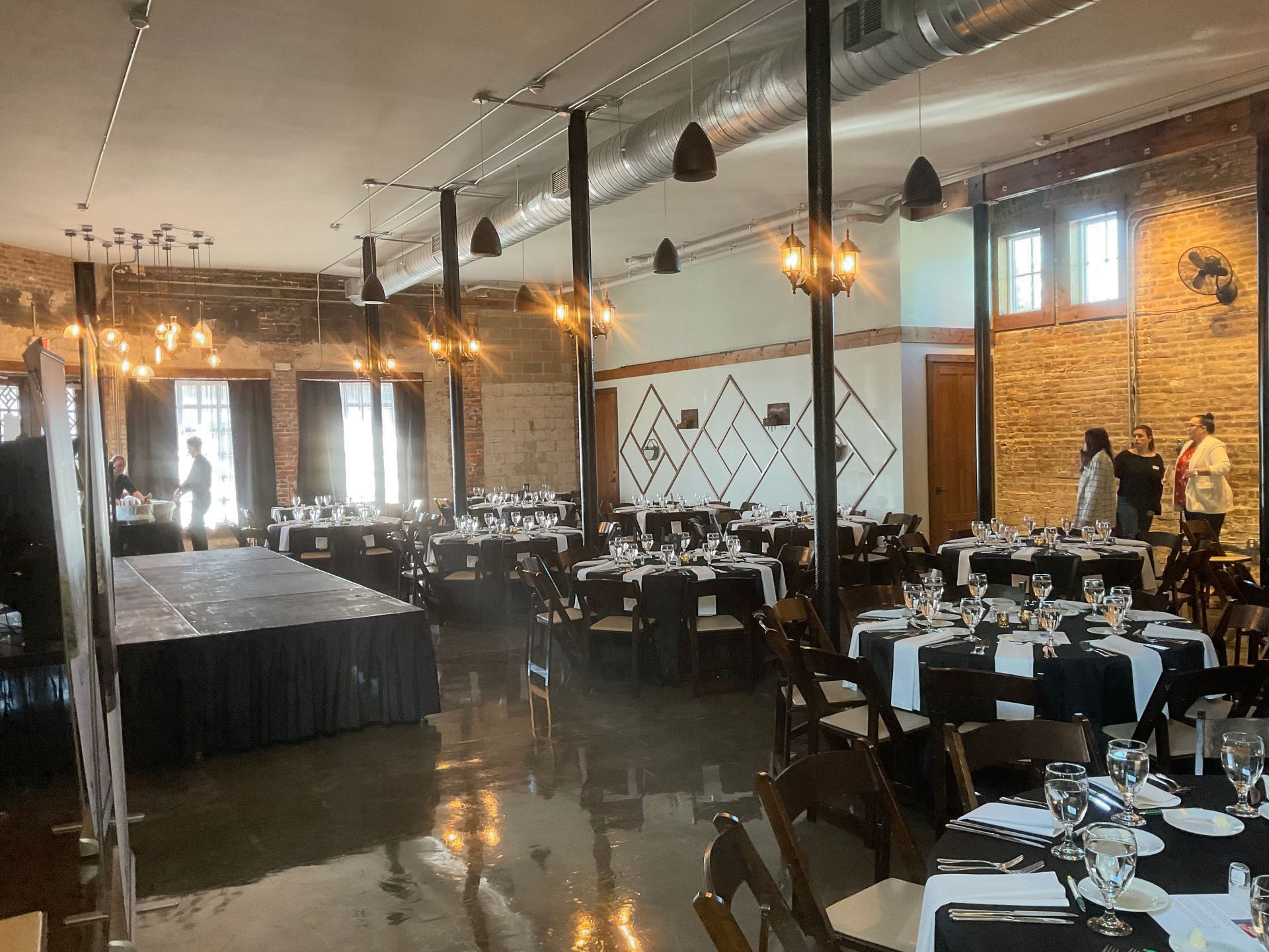 A large room with tables and chairs set up for a wedding reception.