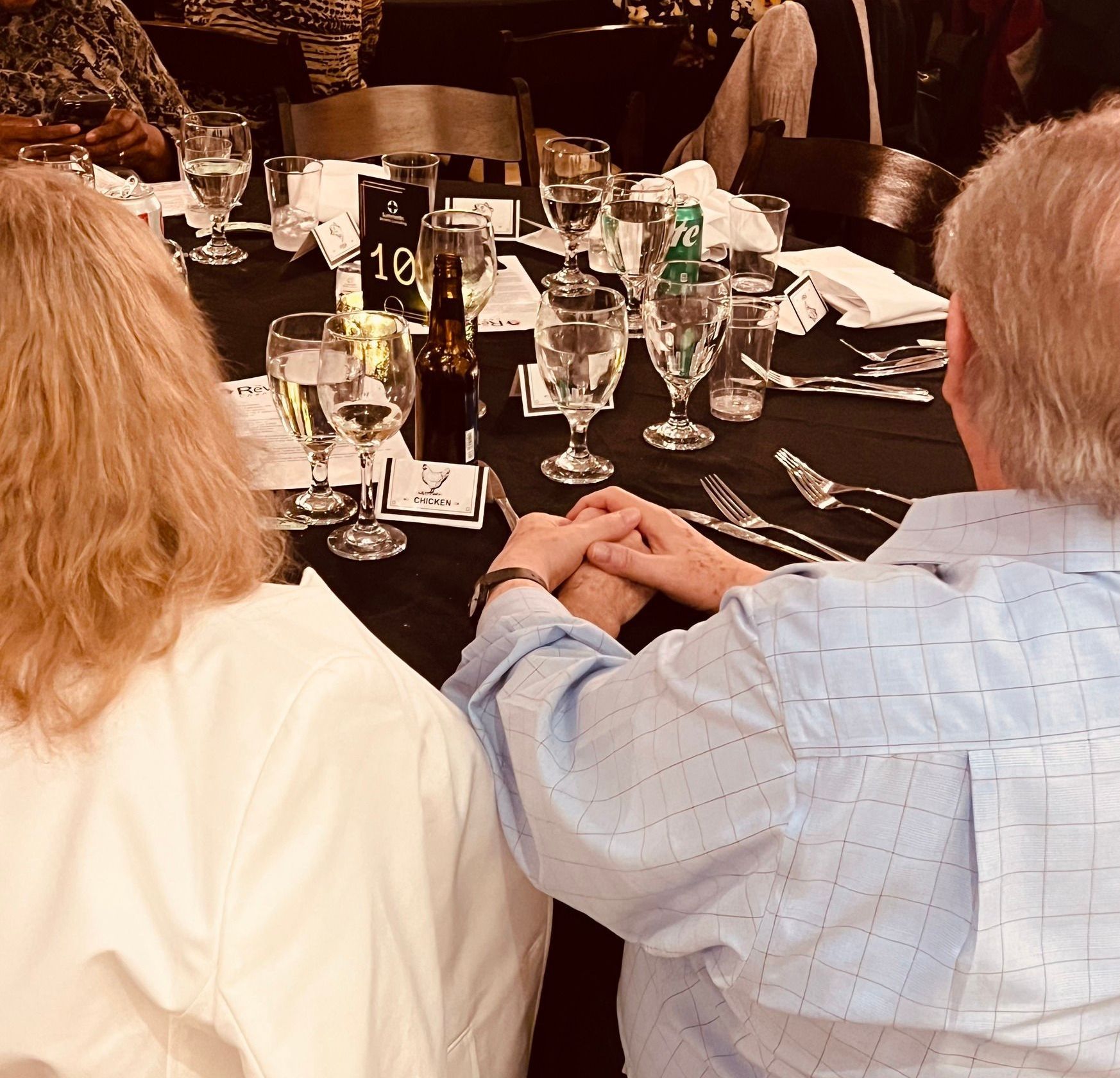 A group of people are sitting at a table with glasses of wine