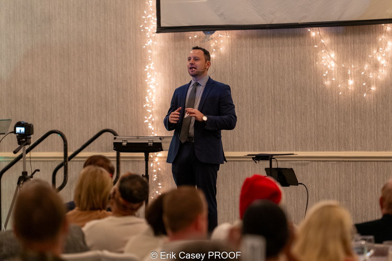 A man in a suit and tie is giving a presentation to a group of people.