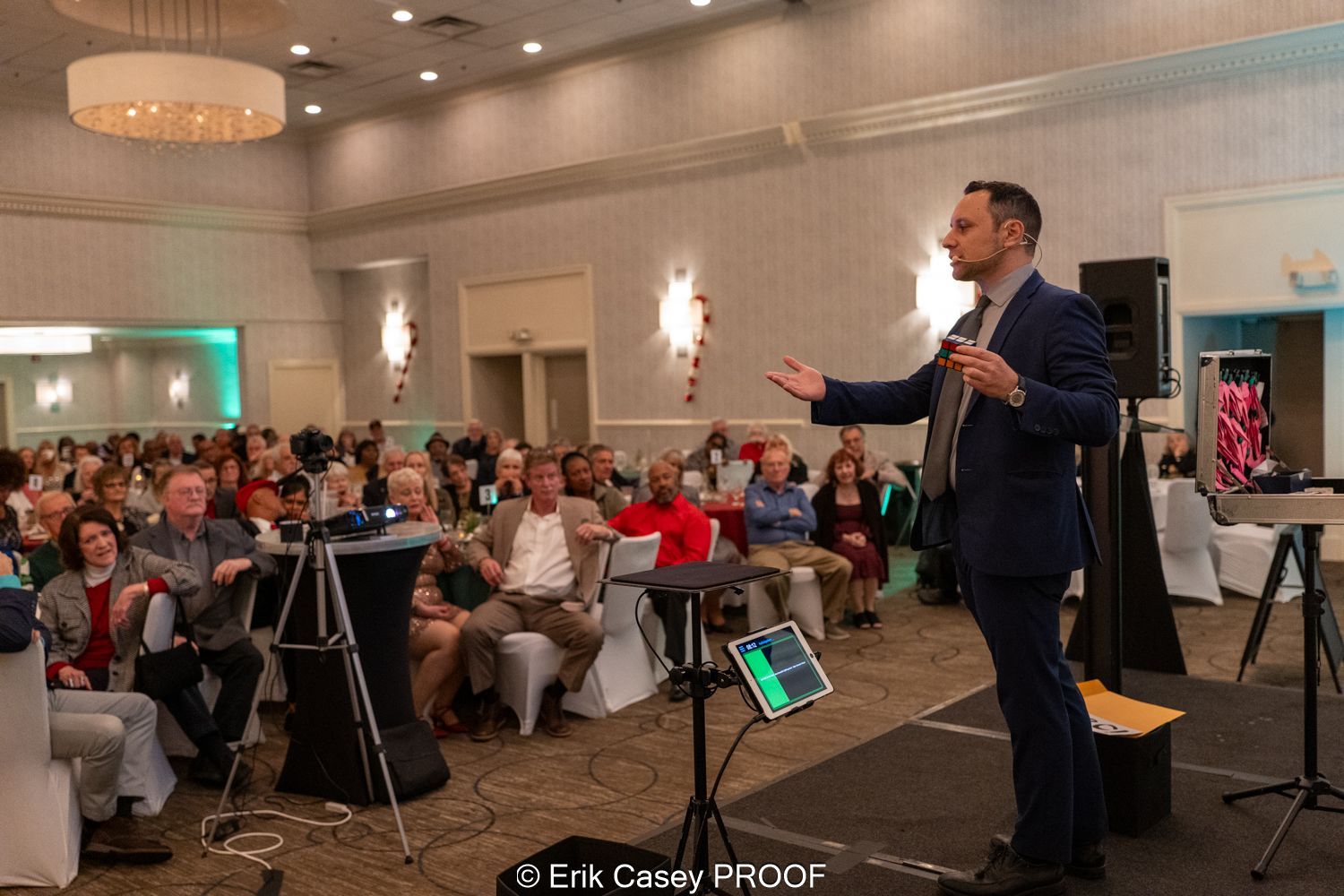 A man in a suit is standing in front of a crowd of people.
