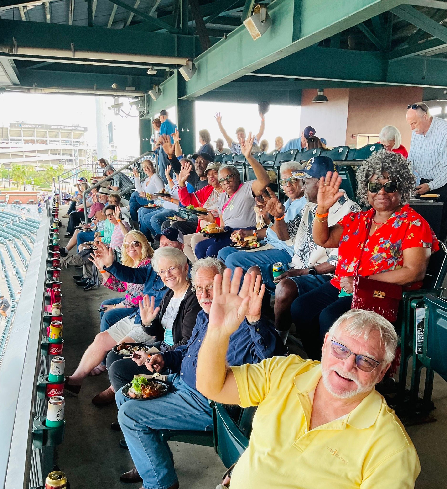 A group of people are sitting in a stadium with their hands in the air