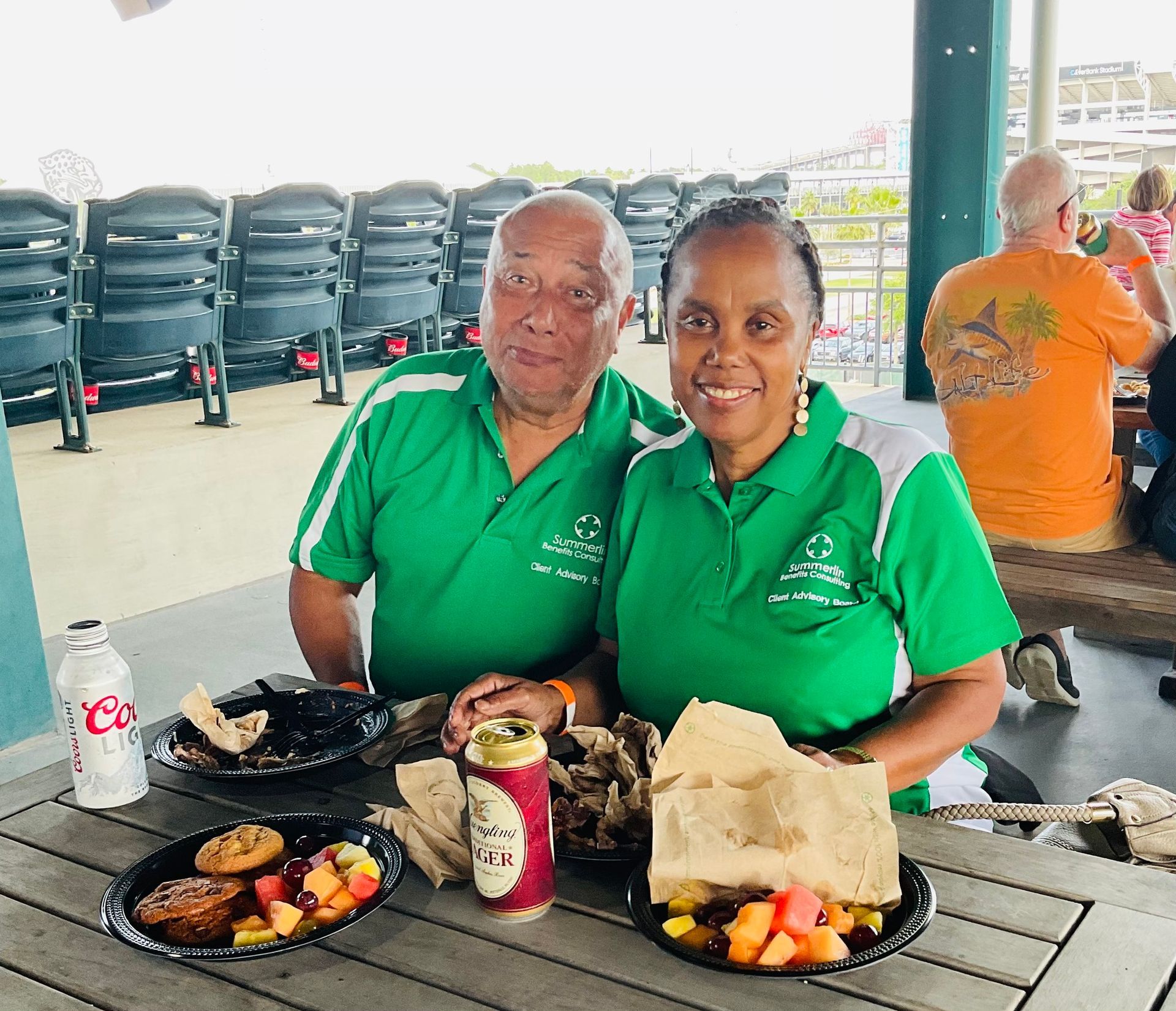 A man and a woman are sitting at a table with plates of food.