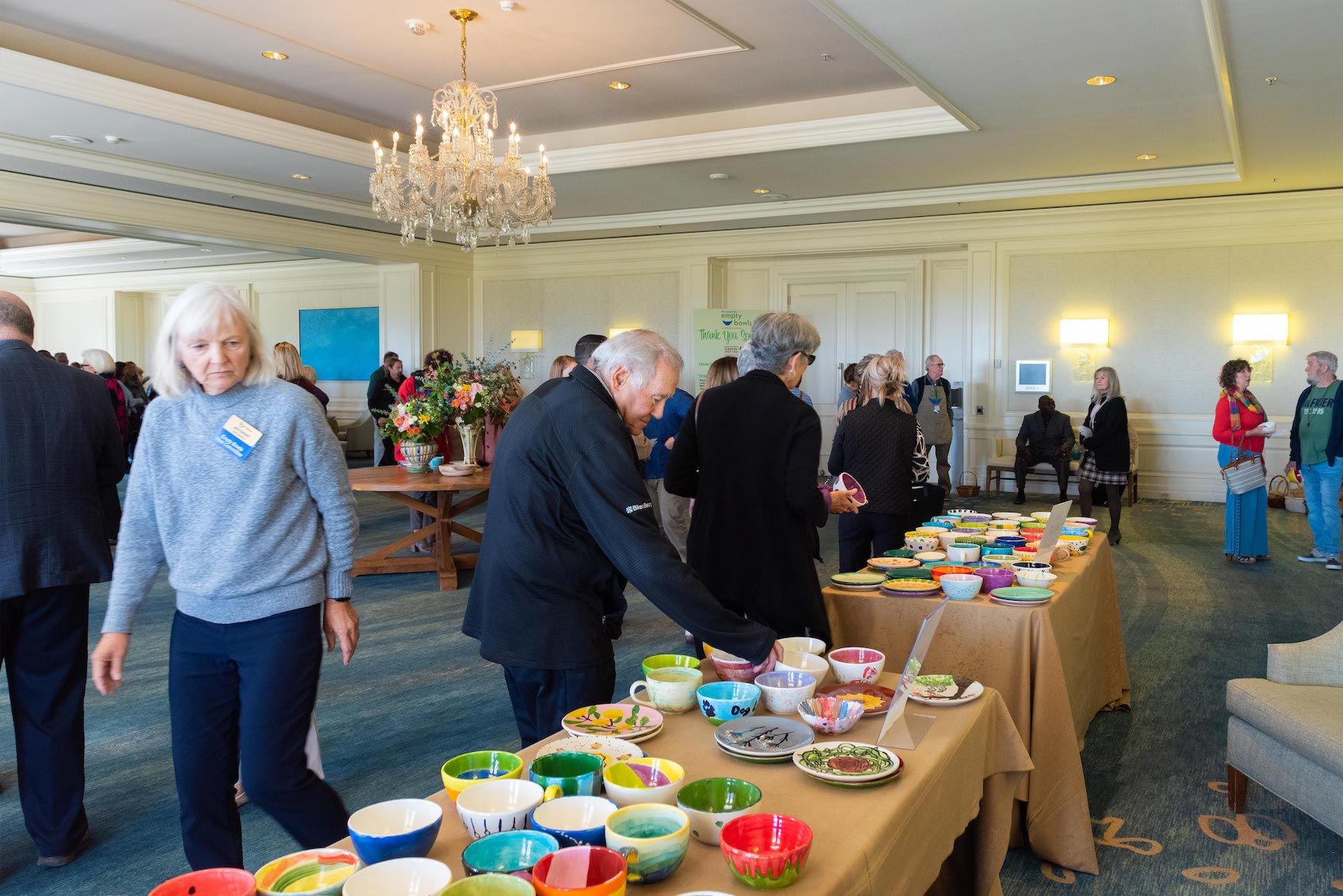 A group of people are standing around a table with bowls on it.