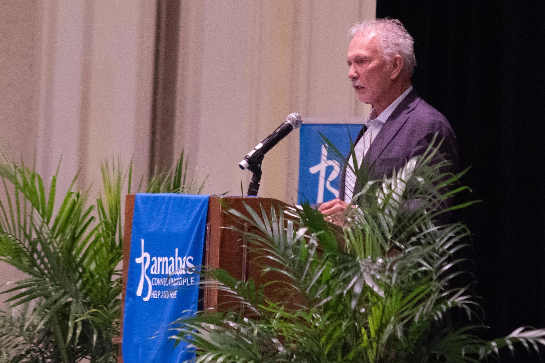 A man is standing at a podium talking into a microphone.