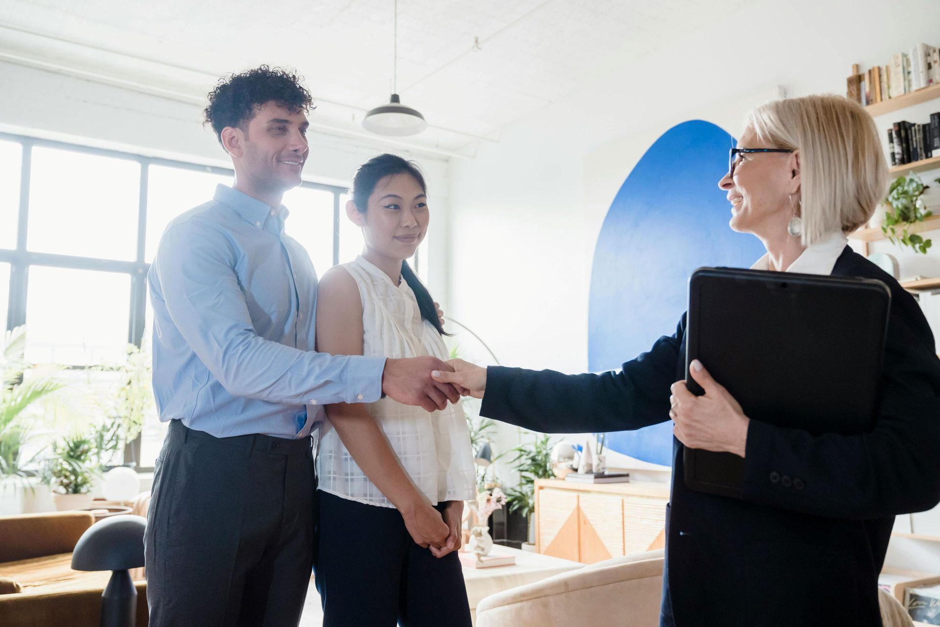 an-elderly-woman-shaking-hands-to-the-man-standing-beside-a-woman