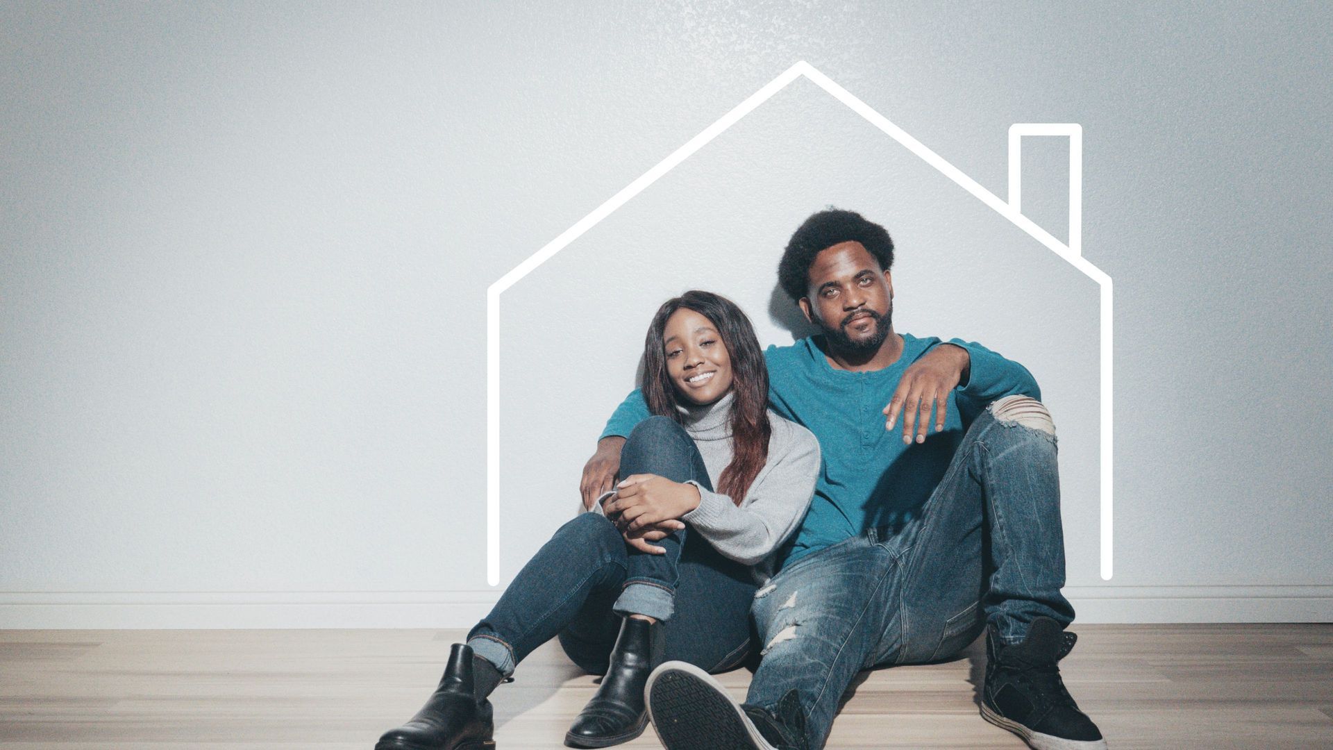 Two people sitting on a floor inside a simple white house outline, smiling and holding a phone