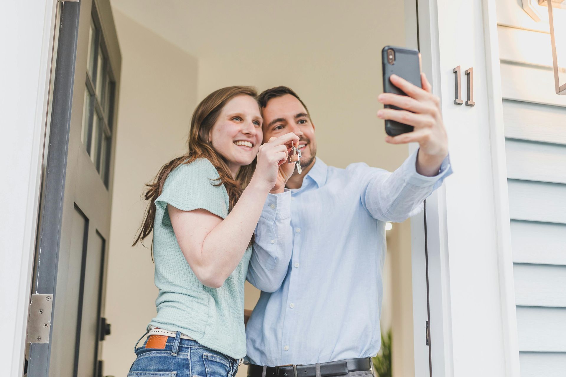 A couple taking a photo outside their first home