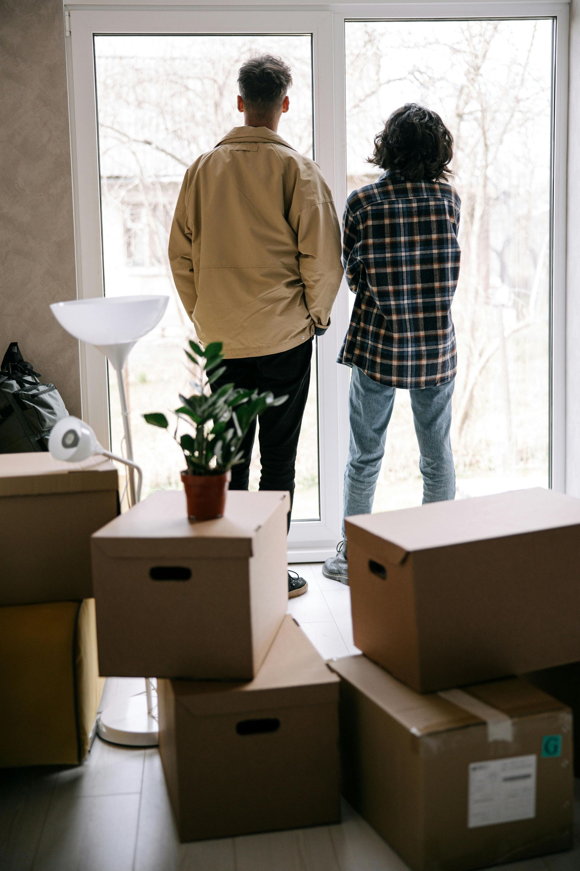 A man and a woman looking outside