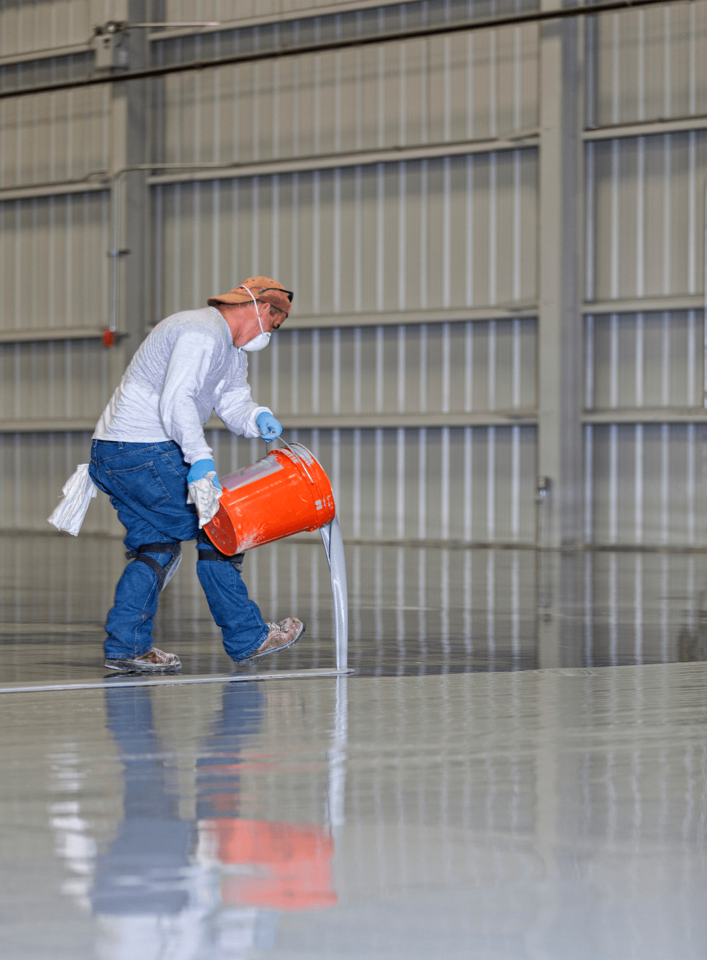 A Man With Face Mask Applying Large Of Amount Of Epoxy On The Floor - Southport, QLD - Supremacy Concreters