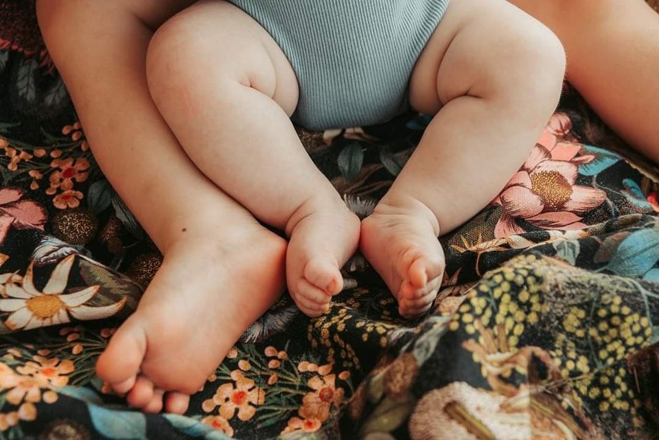 Baby's Legs and Feet Resting on Floral-patterned Blanket — Feathers & Lace Photography in Tarzali, QLD
