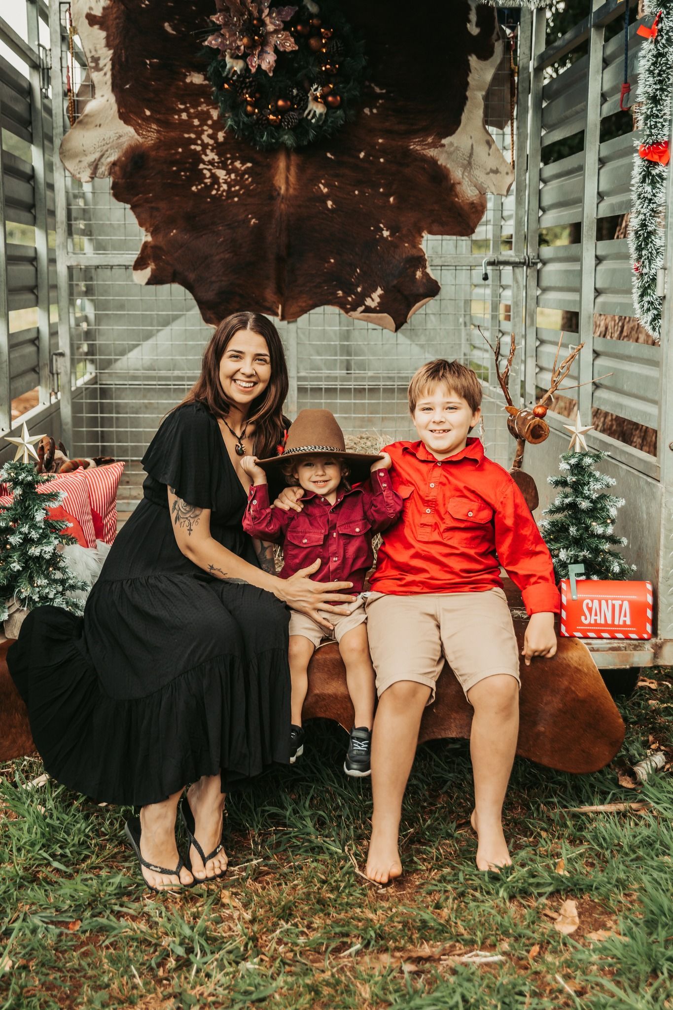 Woman and Two Children Pose on Bench in Front of Cowhide — Feathers & Lace Photography in Tarzali, QLD