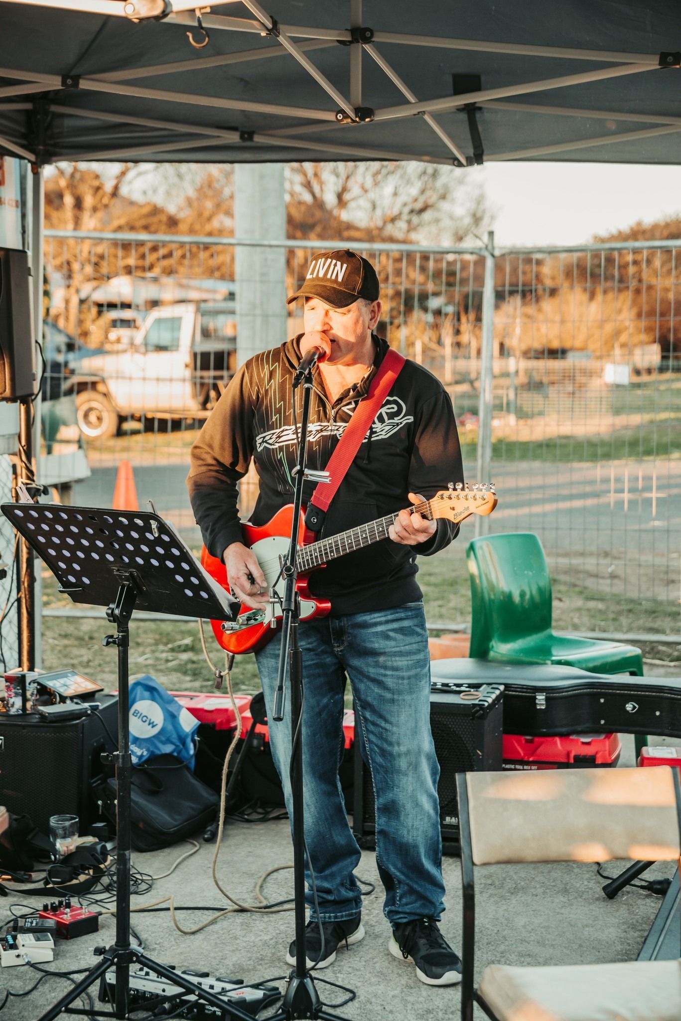 Man Playing a Electric Guitar and Singing Under a Canopy at an Outdoor Event — Feathers & Lace Photography in Tarzali, QLD
