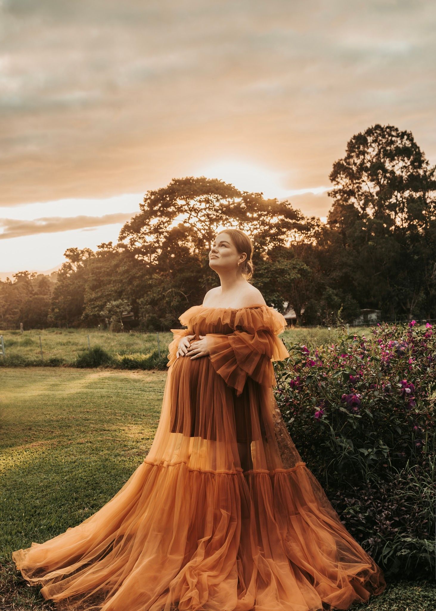 Pregnant Woman in an Orange Gown, Embracing Her Belly — Feathers & Lace Photography in Tarzali, QLD