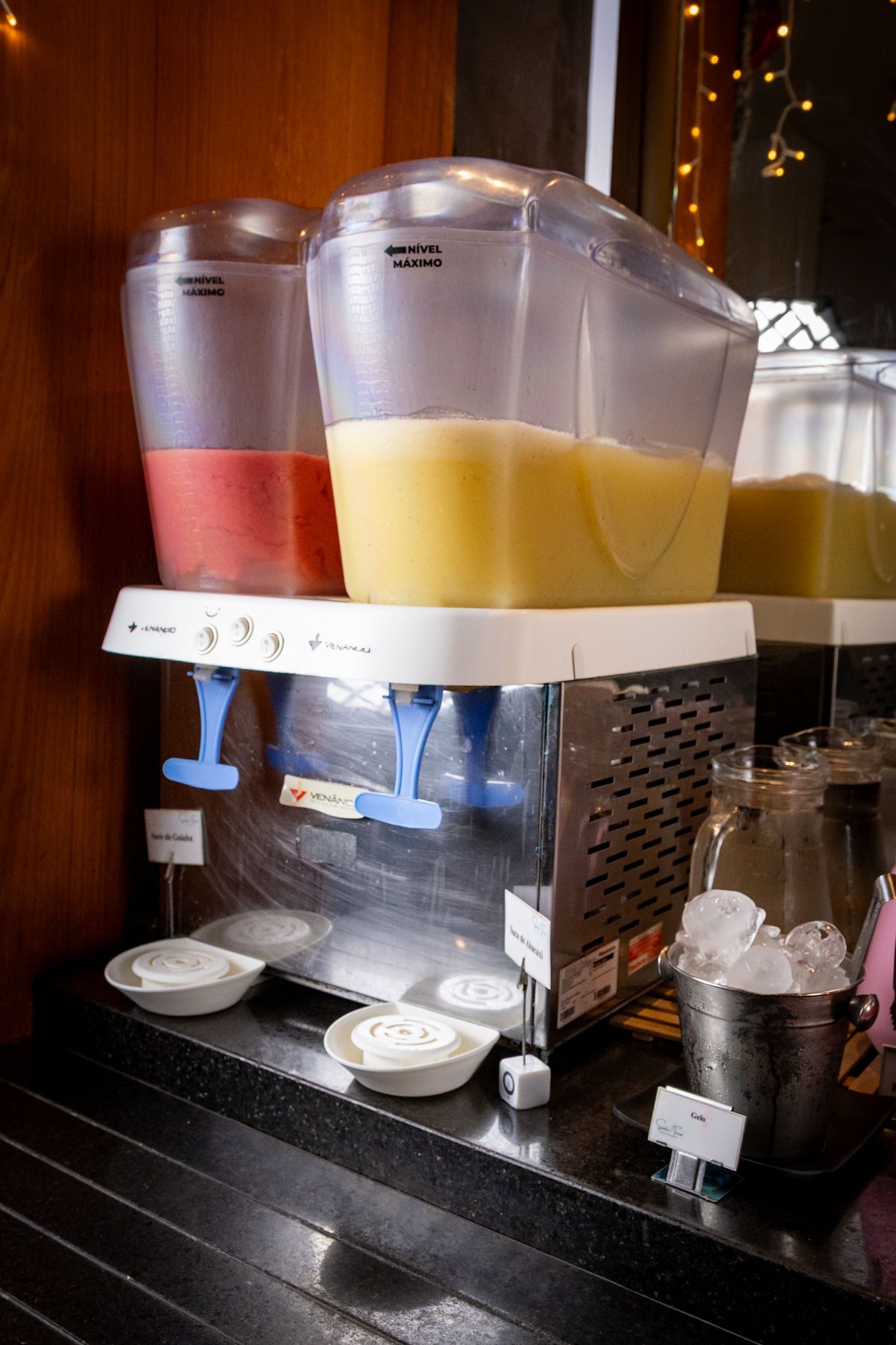 Dispensadores de bebidas com suco de frutas e gelo.